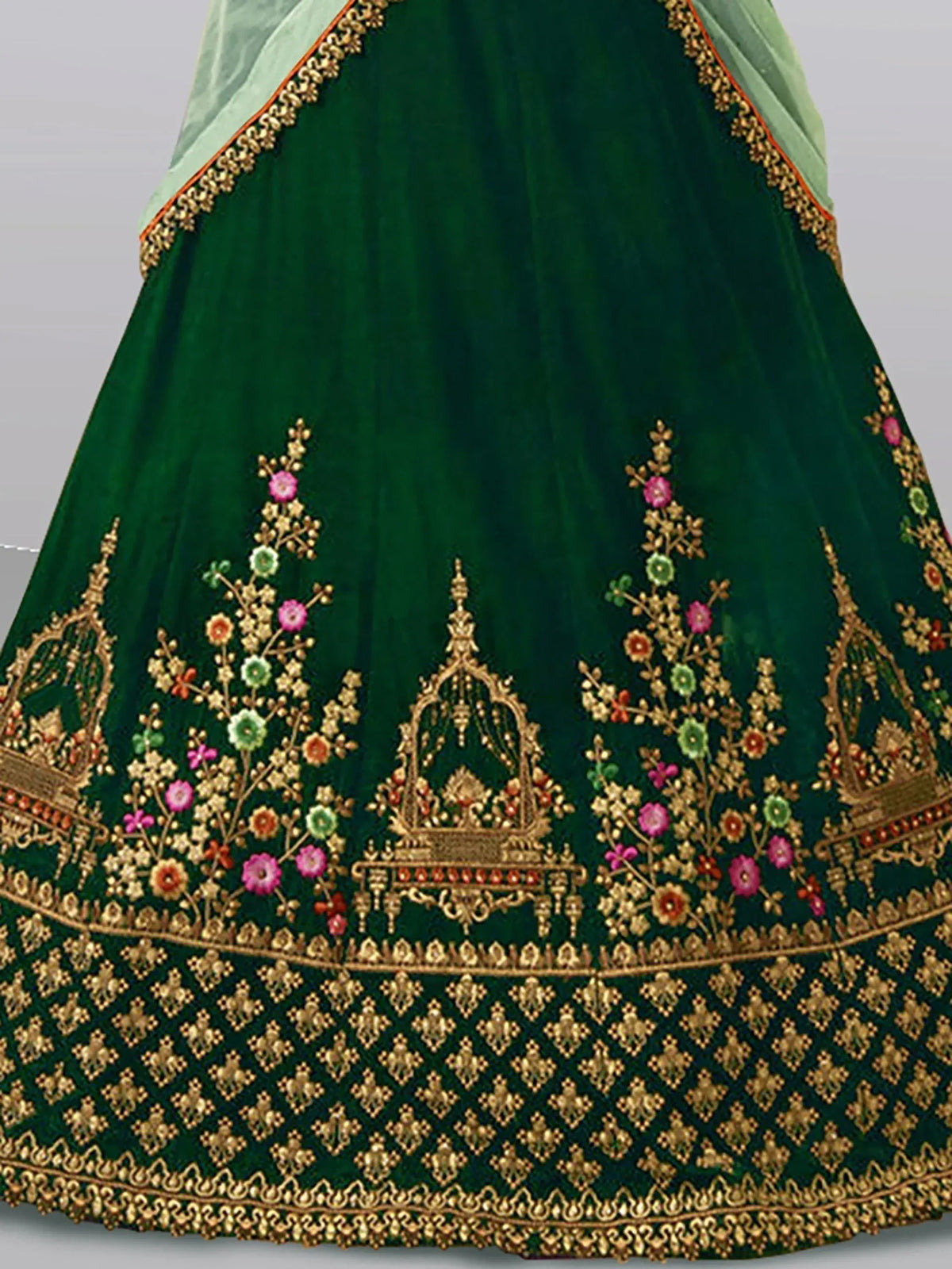 Emerald green velvet lehenga with gold floral embroidery and mirror work, perfect for Indian weddings and festivals.