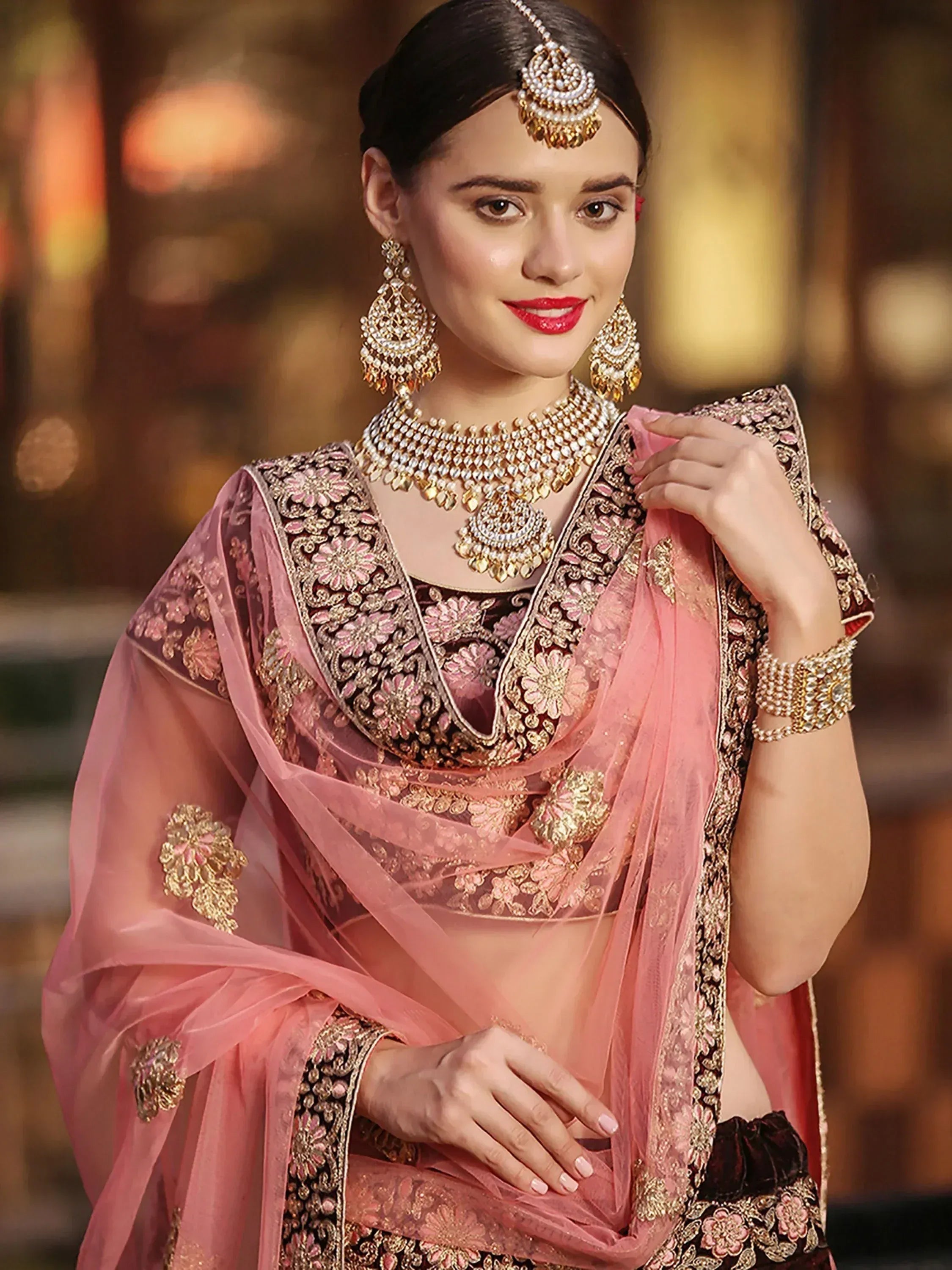 Elegant Indian ethnic wear with pink and gold embroidered lehenga choli, perfect for weddings and festive occasions.