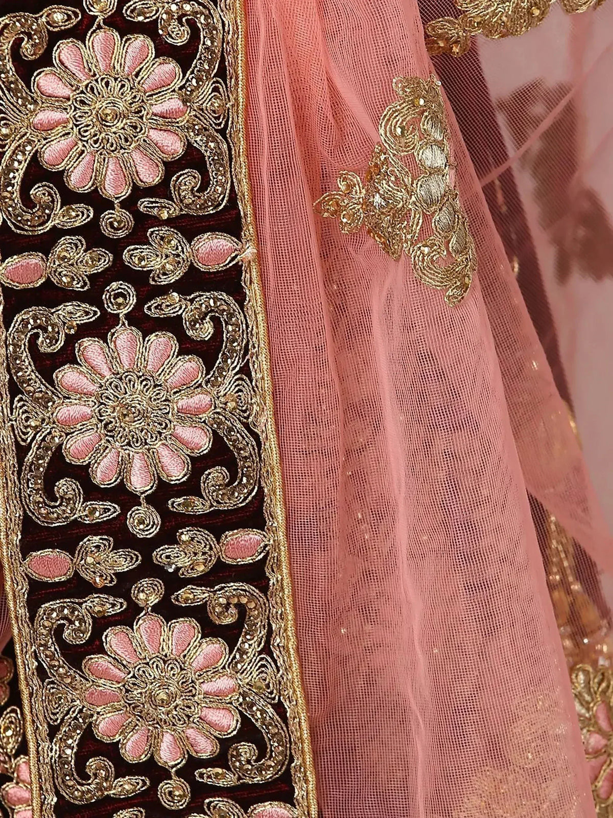 Luxury Indian ethnic wear with intricate gold and pink floral embroidery on velvet and net fabric