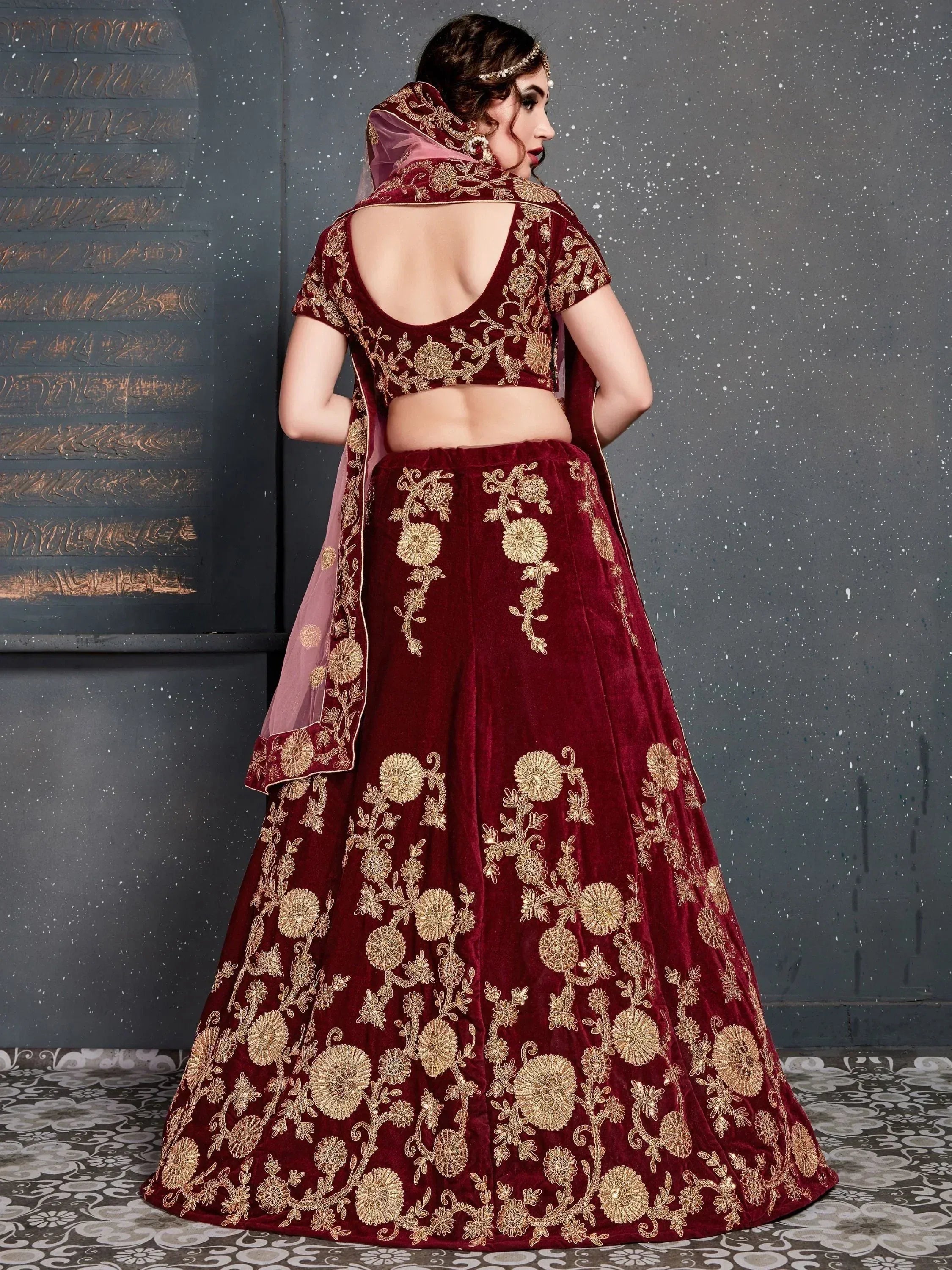 Maroon velvet lehenga choli with gold floral embroidery, backless blouse, and dupatta for Indian weddings
