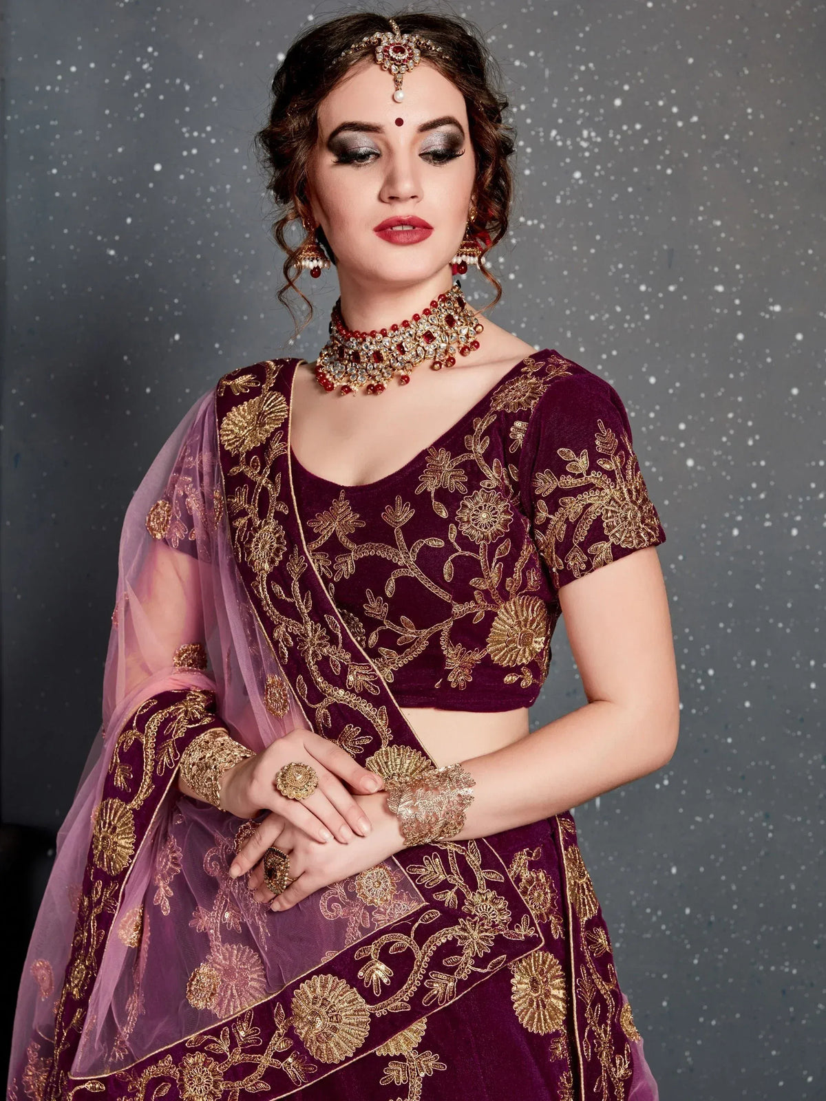 Elegant maroon velvet lehenga choli with gold floral embroidery and matching dupatta, perfect for Indian weddings and festive occasions.