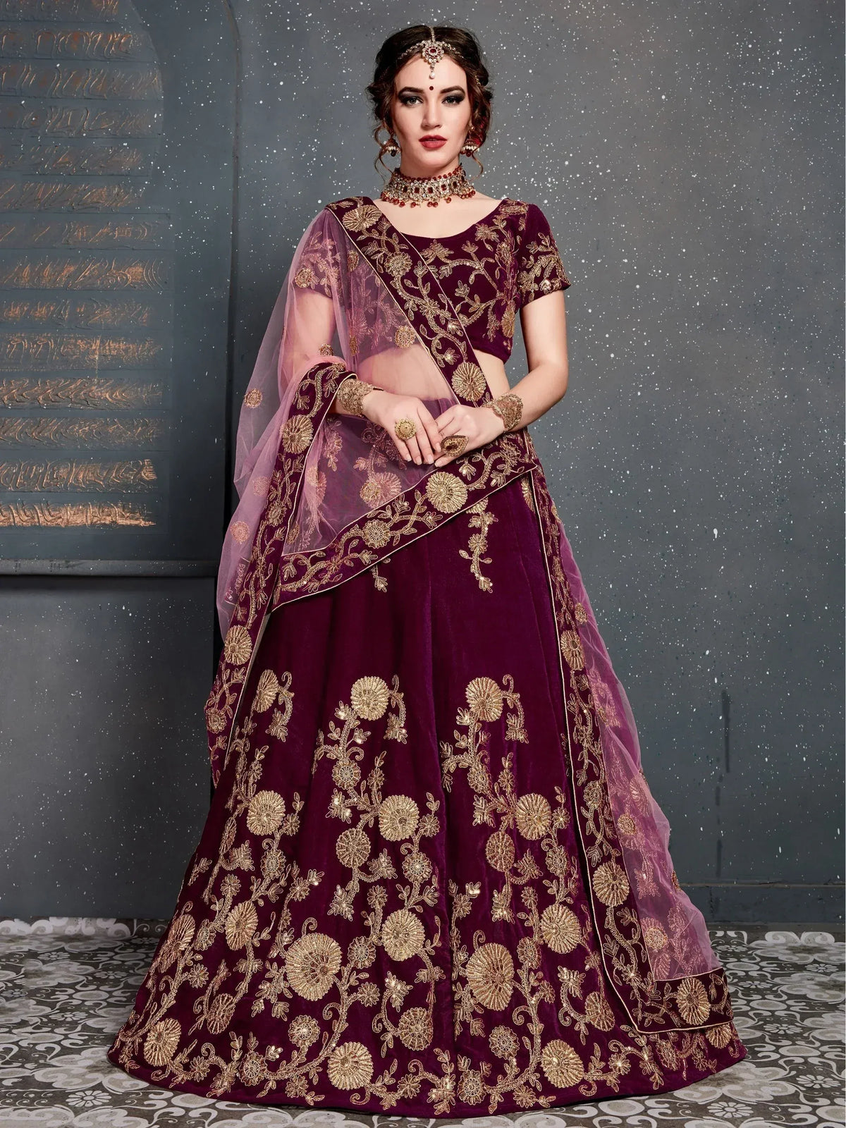 Burgundy velvet lehenga choli with gold floral embroidery and sheer dupatta, perfect for Indian weddings