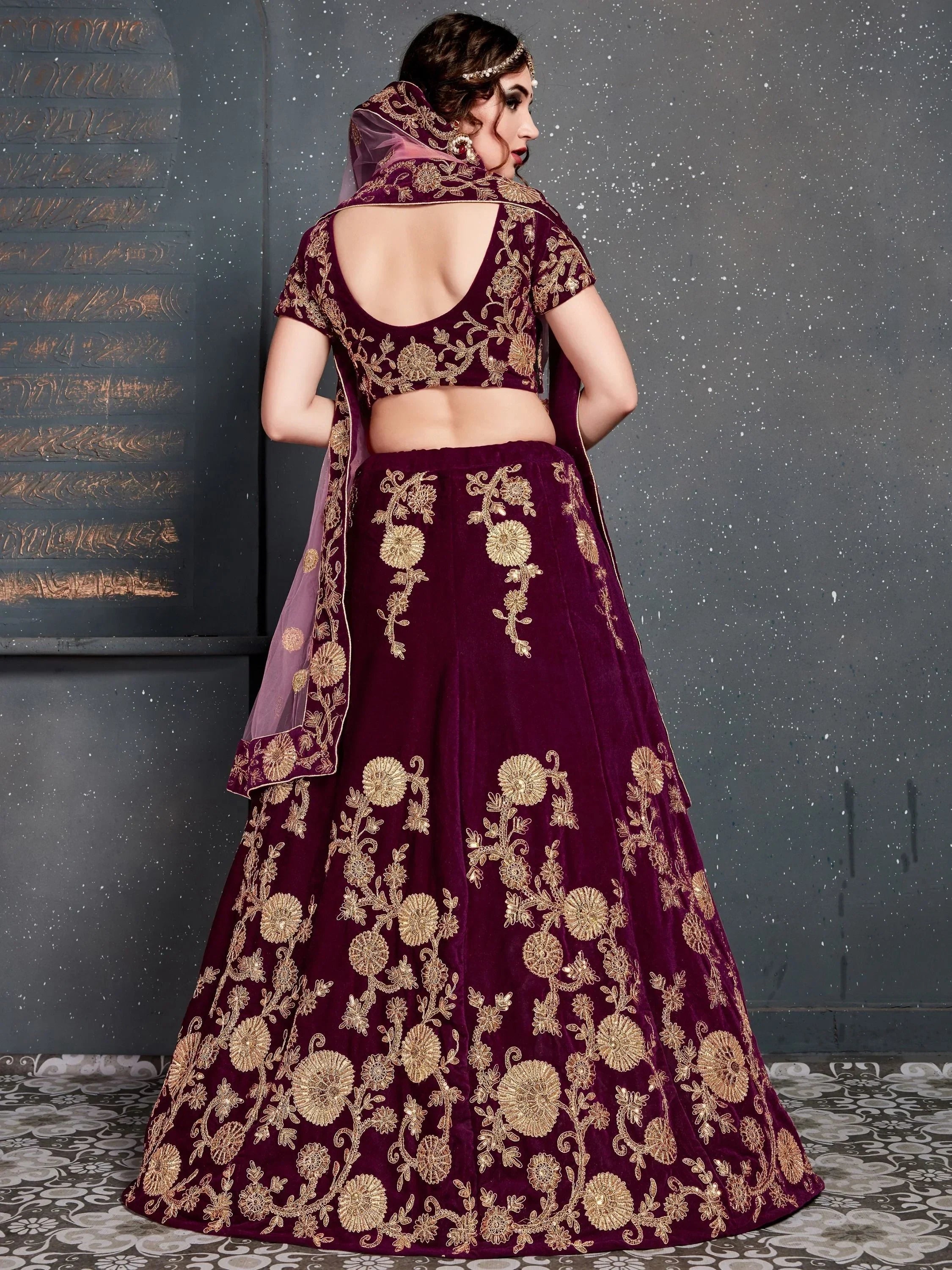 Elegant maroon velvet lehenga choli with gold floral embroidery, perfect for Indian weddings and festive occasions.