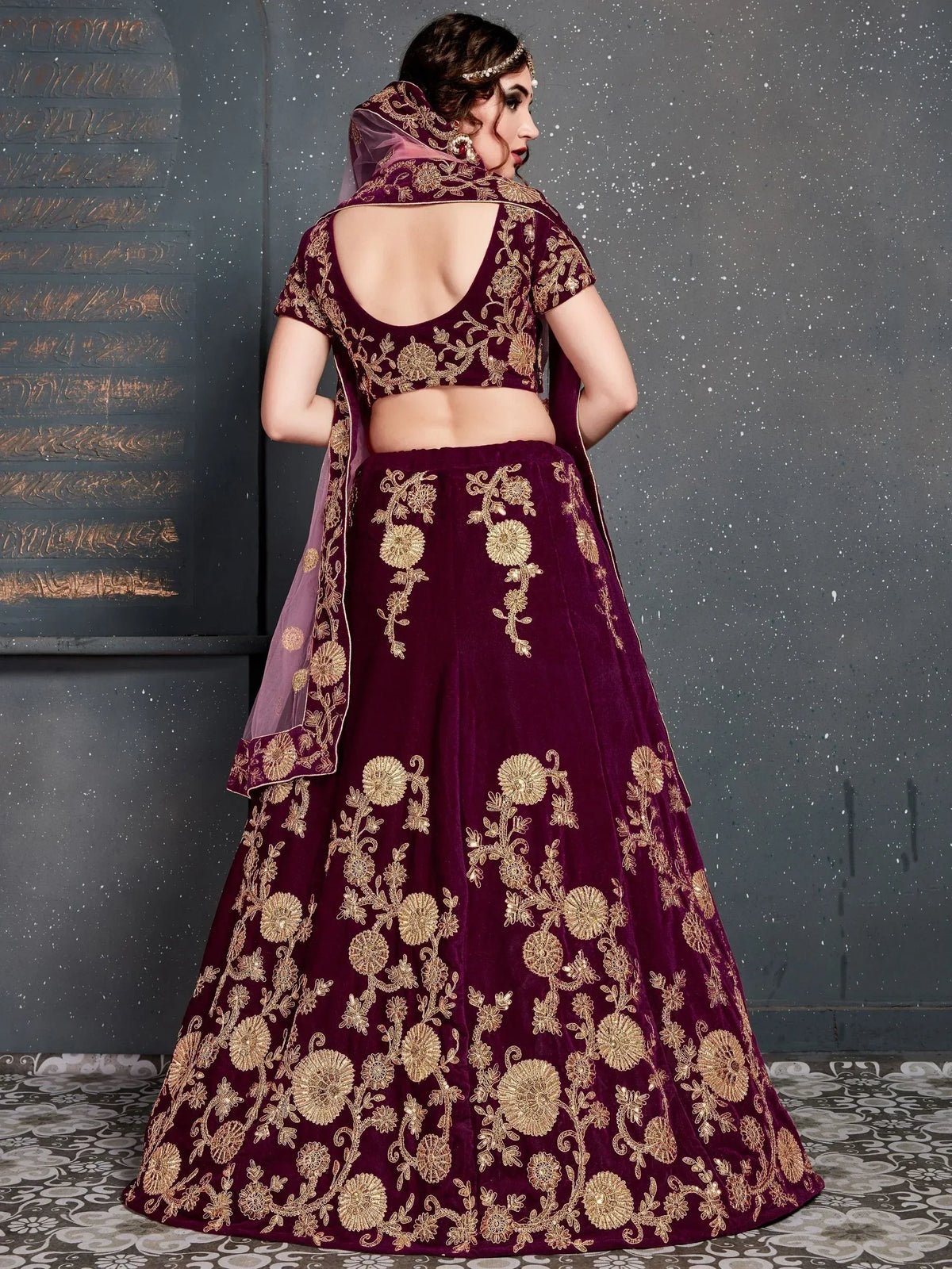 Elegant maroon velvet lehenga choli with gold floral embroidery, perfect for Indian weddings and festive occasions.