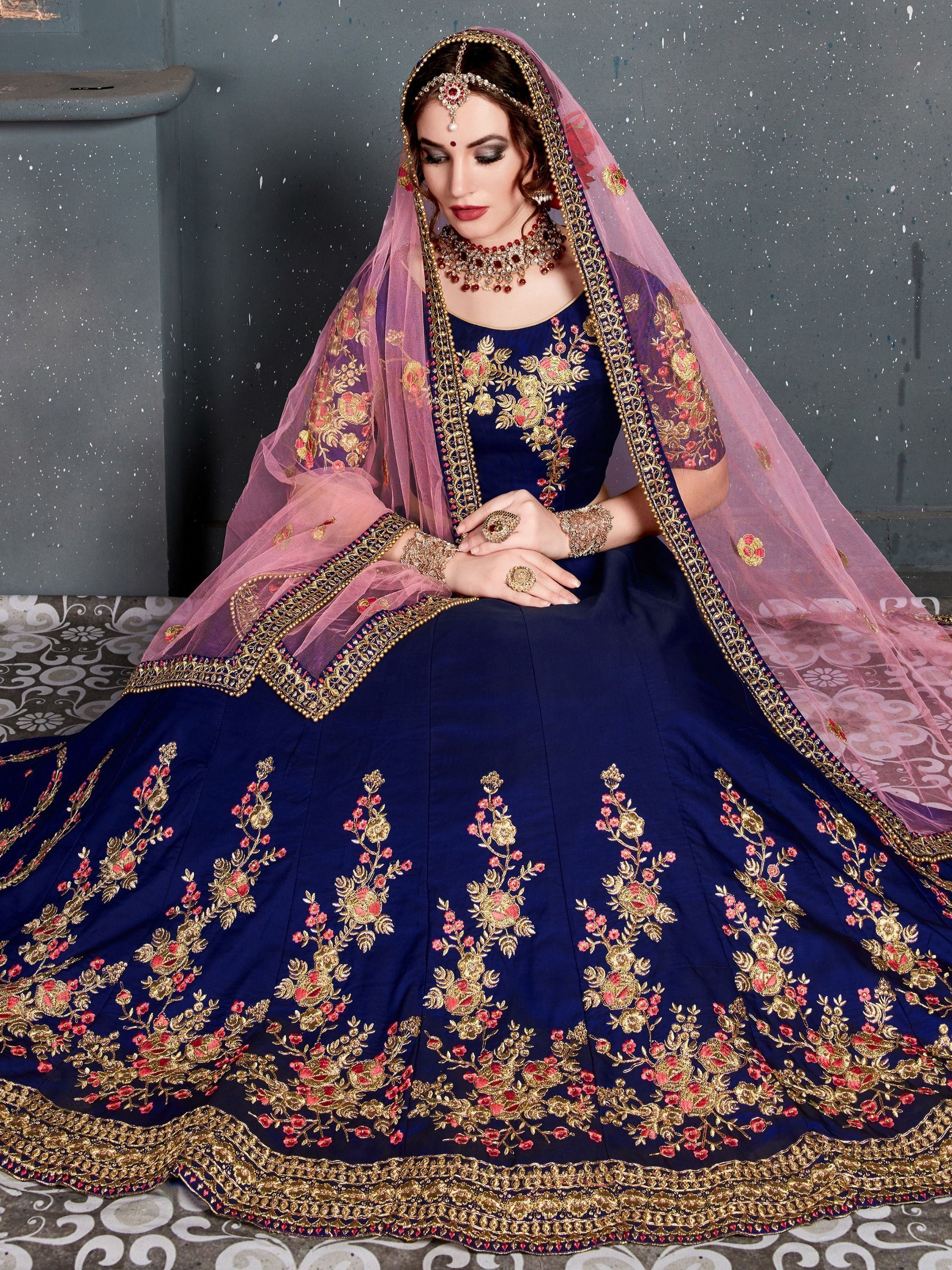 Navy blue designer lehenga choli with gold and pink floral embroidery, paired with sheer pink dupatta for Indian weddings.