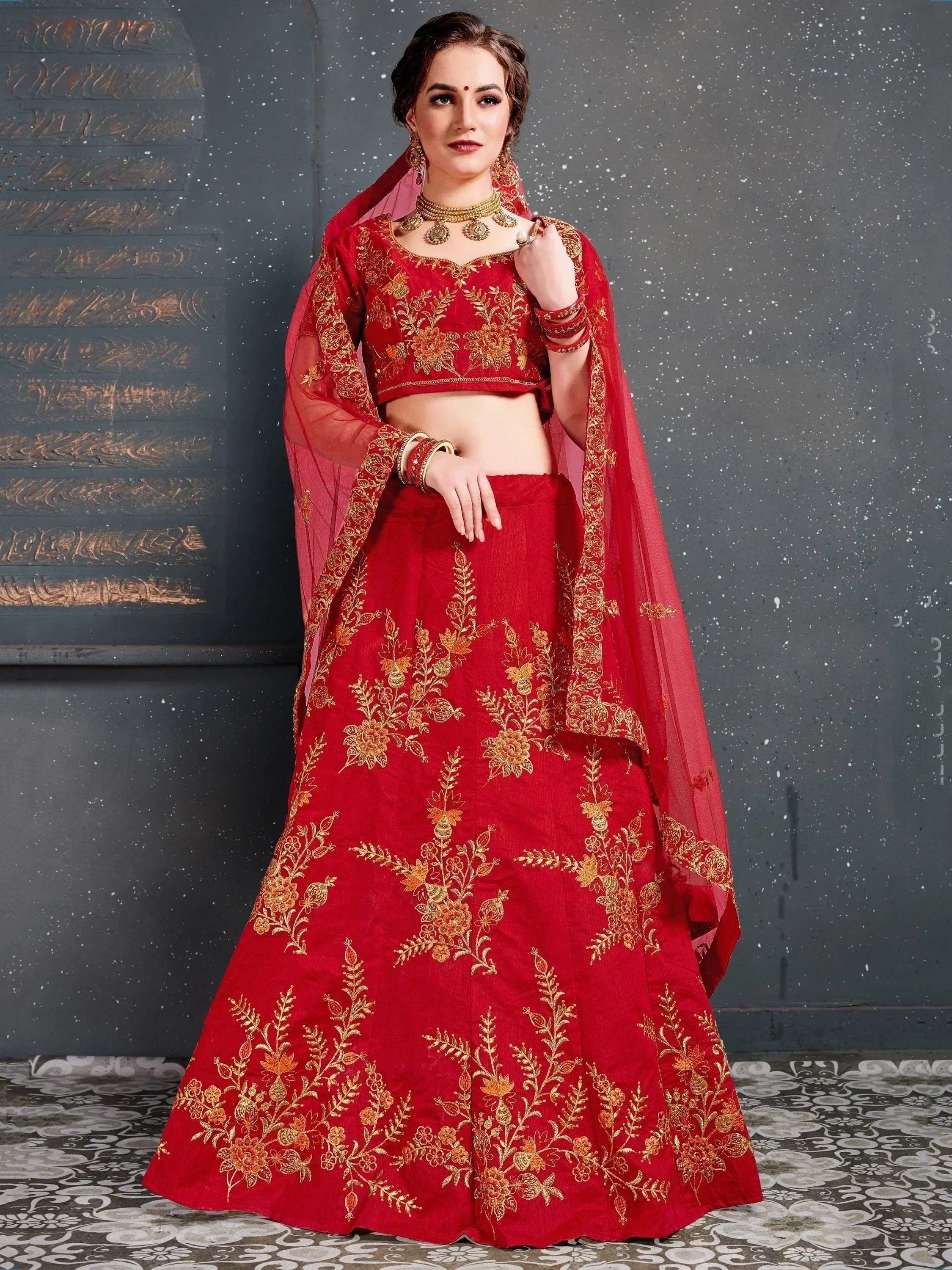 Red embroidered lehenga choli with gold floral work, perfect for Indian weddings and festive occasions.