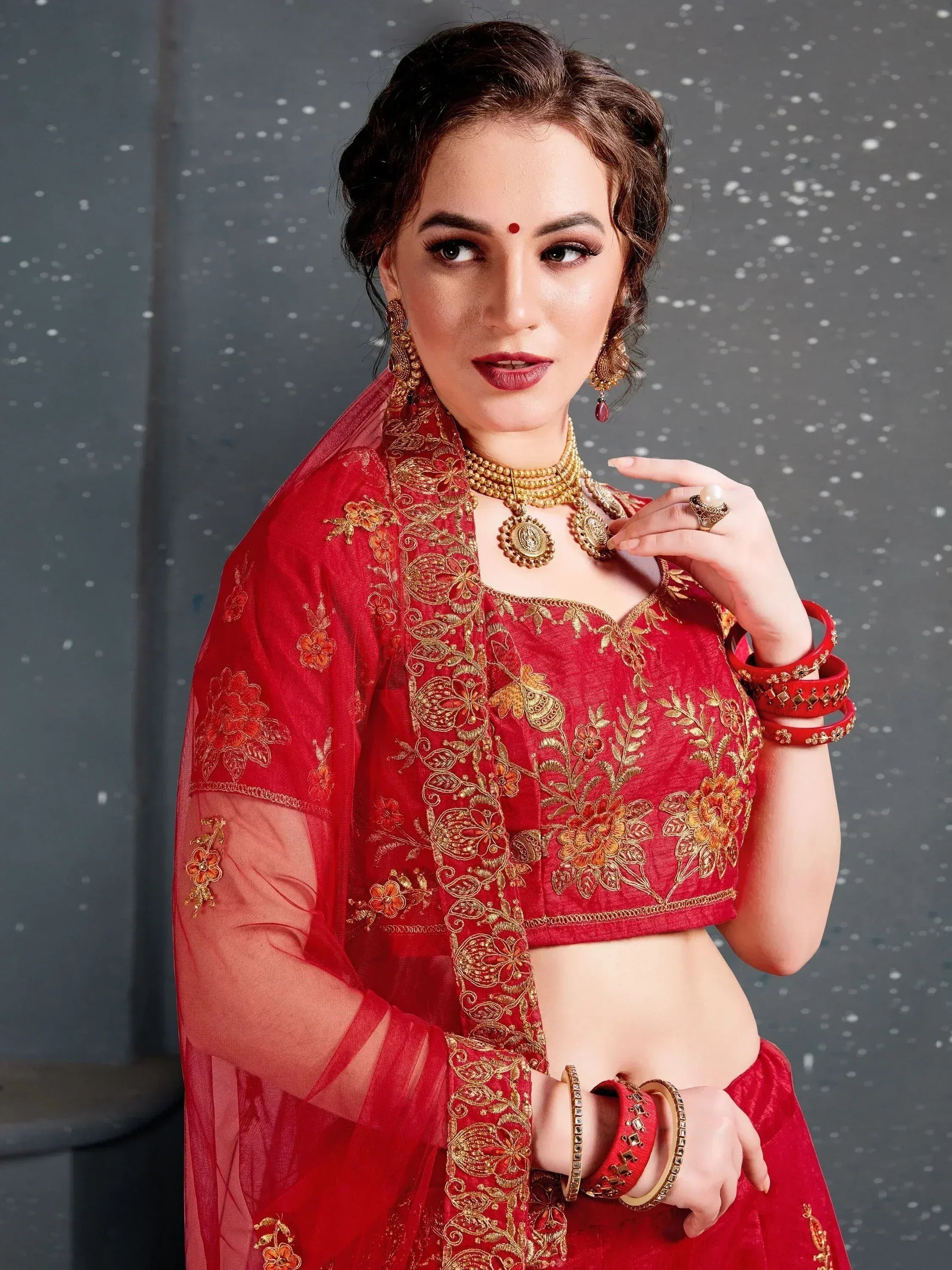 Red embroidered lehenga choli with gold floral work, matching dupatta, and traditional jewelry for Indian ethnic wear
