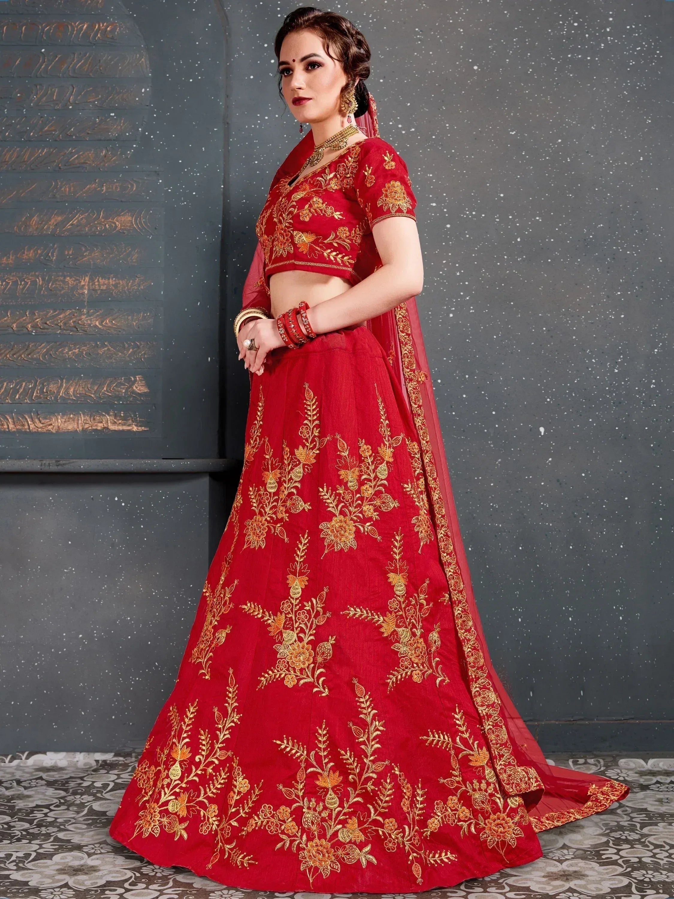Red embroidered lehenga choli with gold floral work, perfect for Indian weddings and festive occasions.
