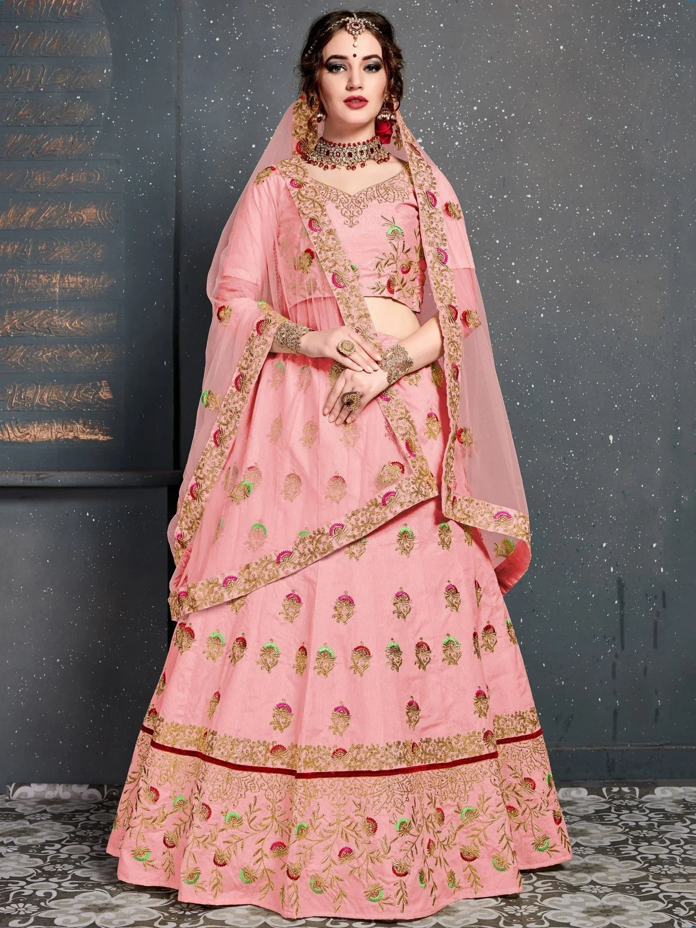 Pink embroidered lehenga choli with gold floral motifs and matching dupatta, ideal for Indian weddings and festive occasions.
