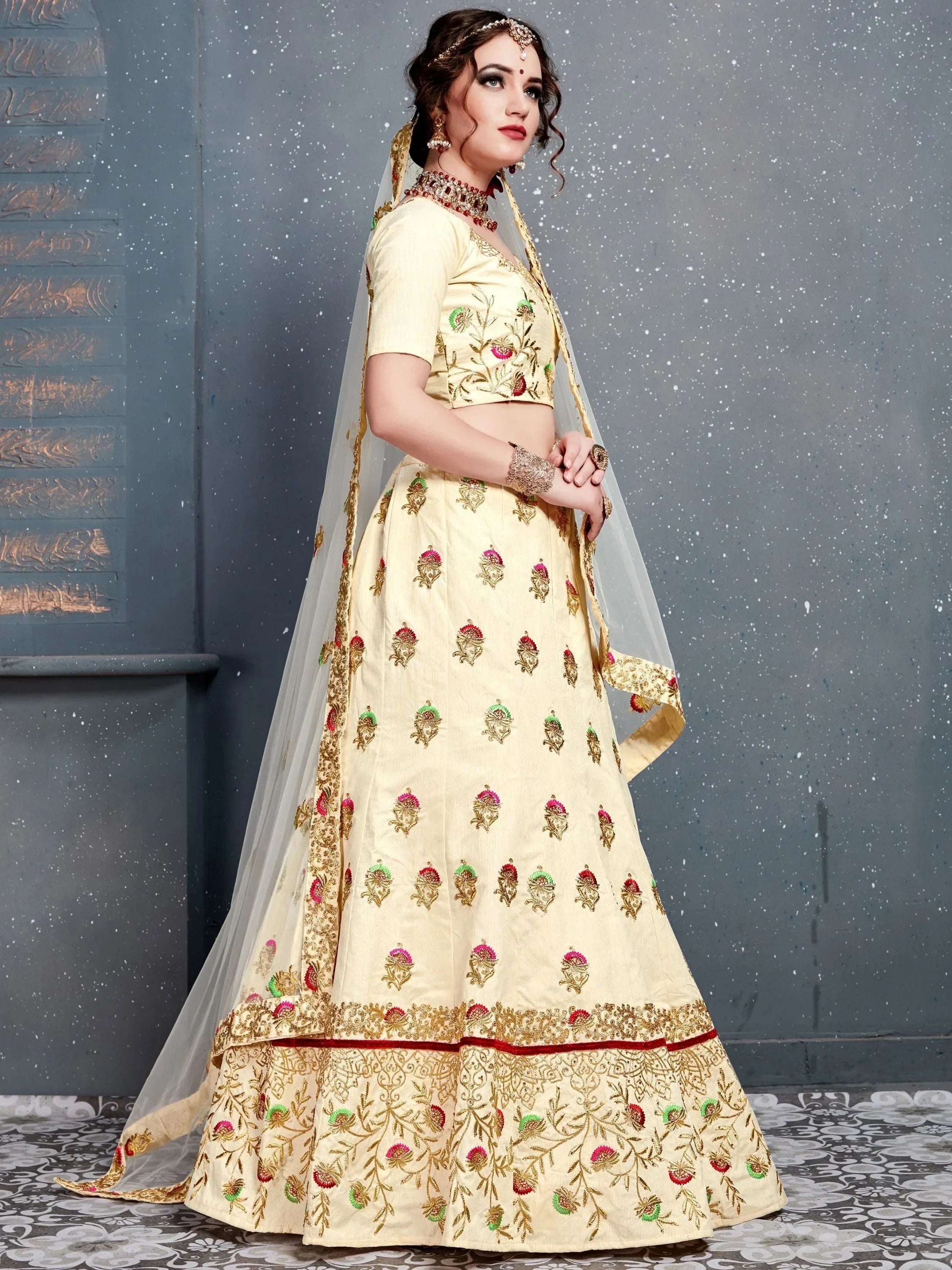Cream embroidered lehenga choli with floral motifs, dupatta, and traditional jewelry for Indian ethnic wear