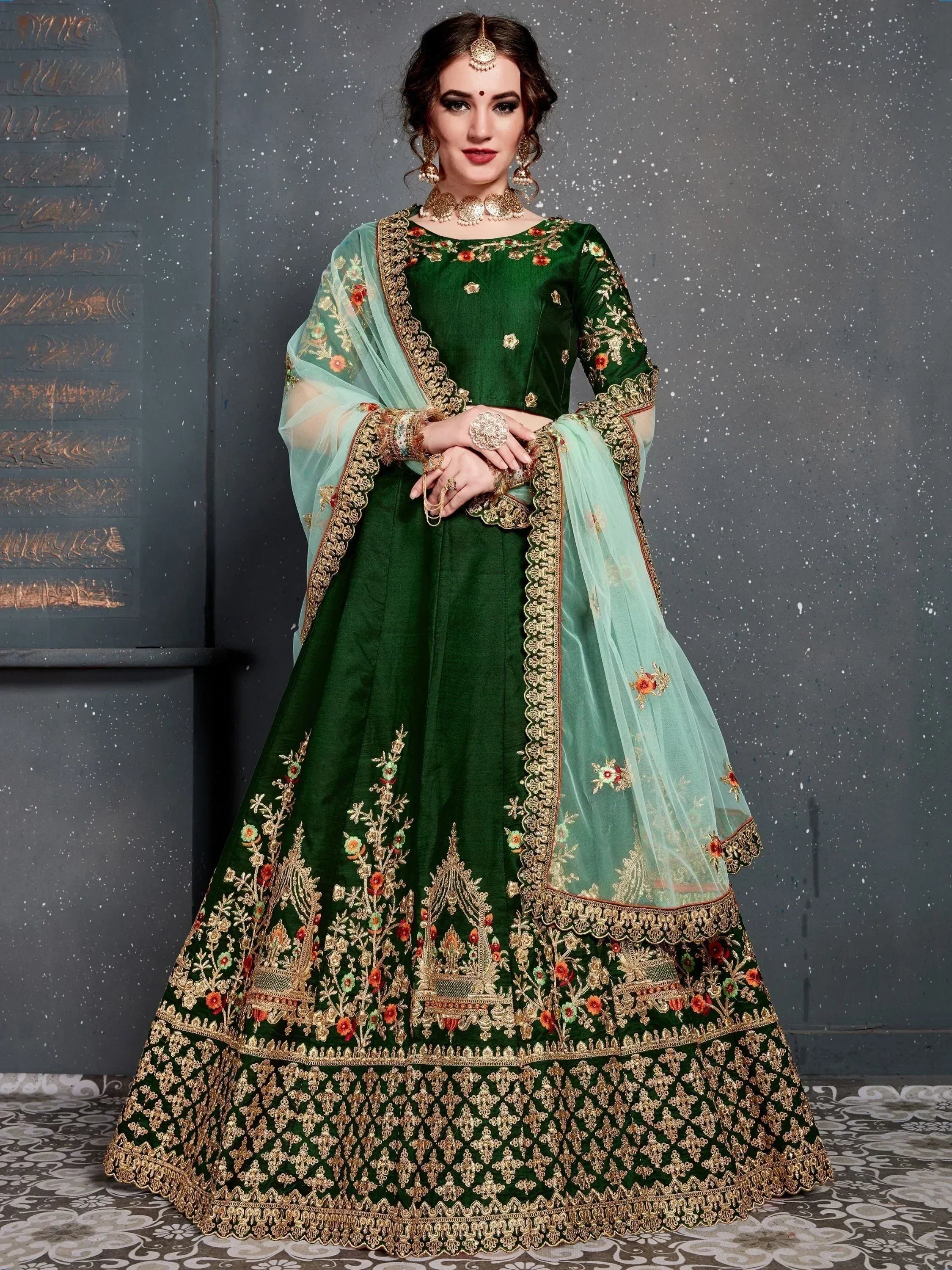 Emerald green designer lehenga choli with gold floral embroidery and sheer mint dupatta, perfect for Indian weddings.