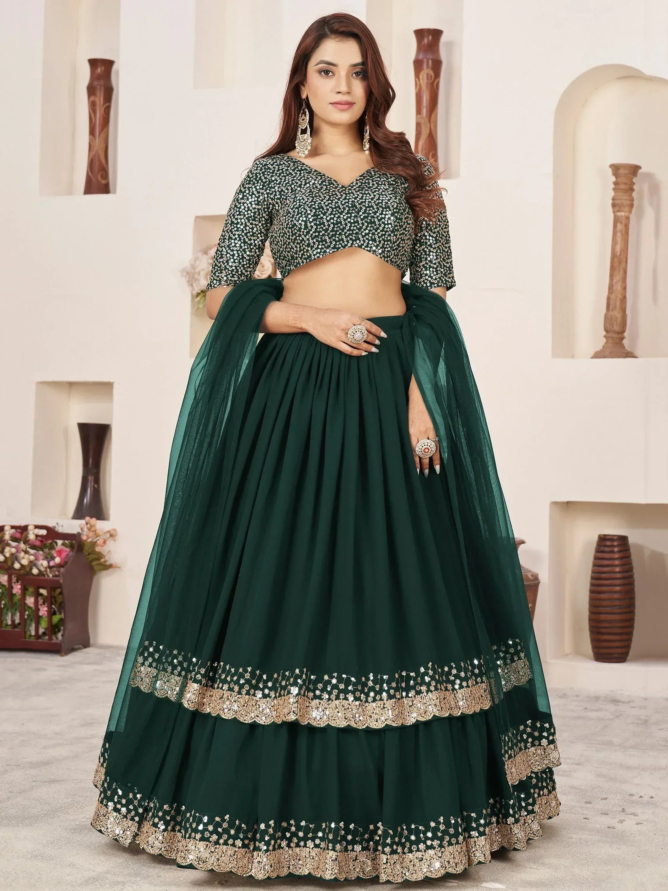 Emerald green designer lehenga choli with sequin blouse and gold embroidery, perfect for Indian ethnic occasions.