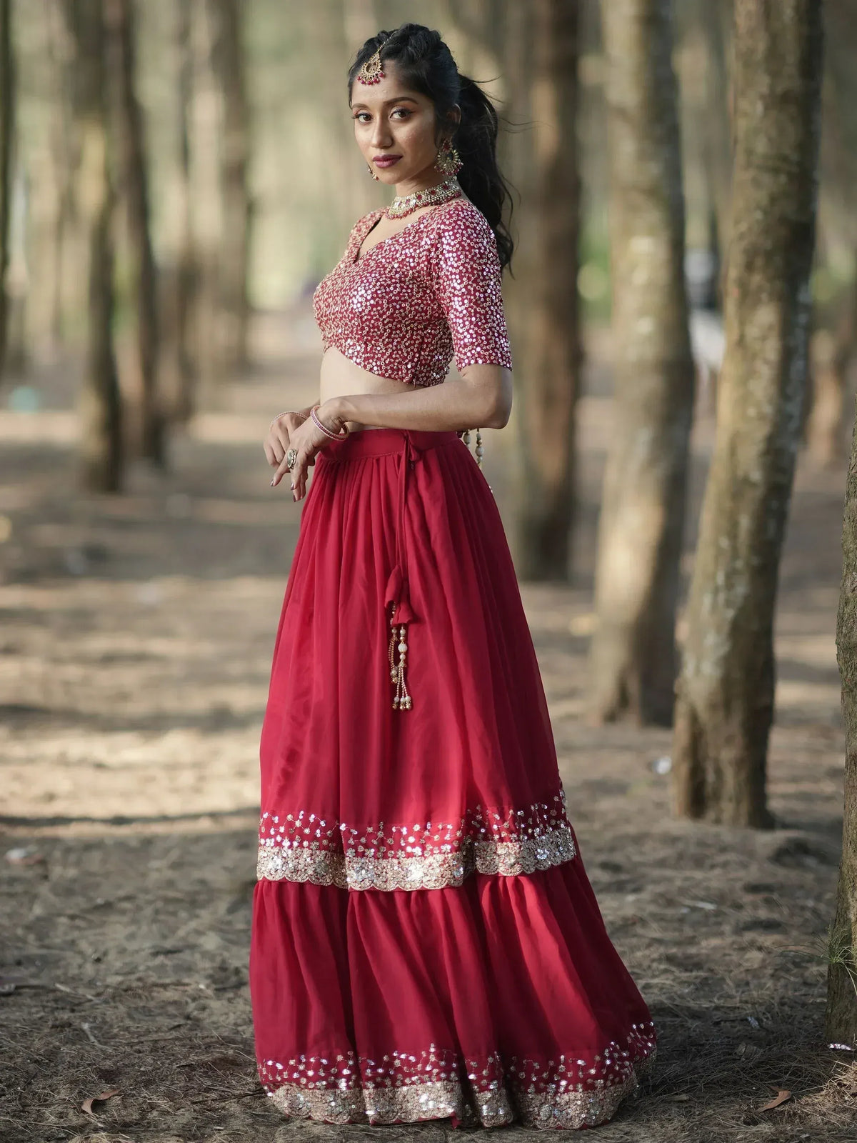 Woman in maroon sequin lehenga choli with gold embroidery, styled for Indian ethnic wear occasions