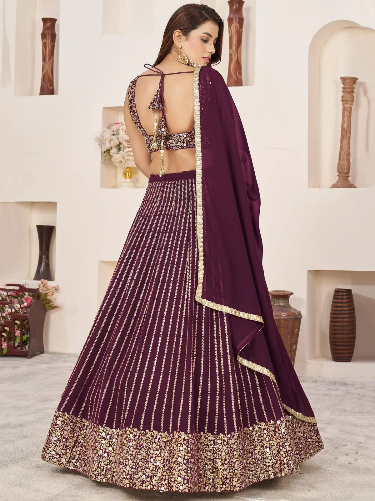 Elegant maroon lehenga choli with gold embroidery and sequin detailing, perfect for Indian weddings and festive occasions.