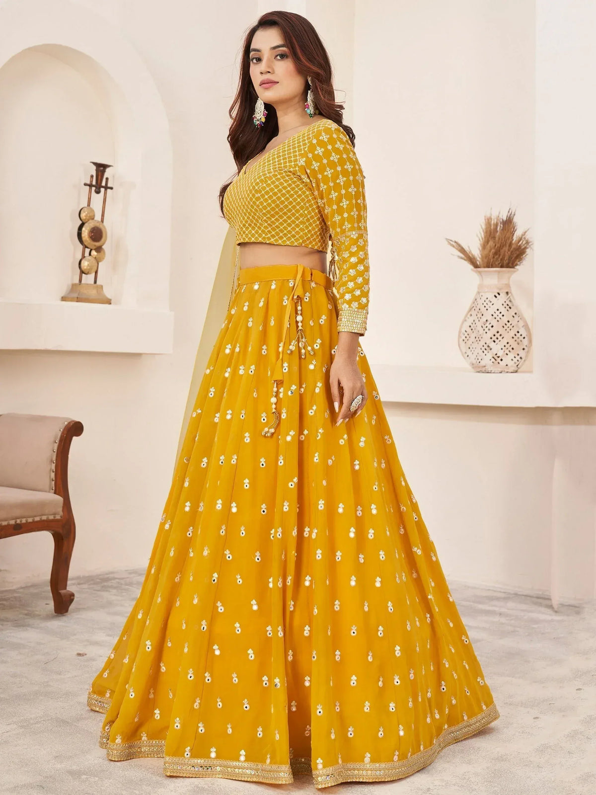Mustard yellow designer lehenga choli with floral embroidery and mirror work, perfect for Indian ethnic occasions.