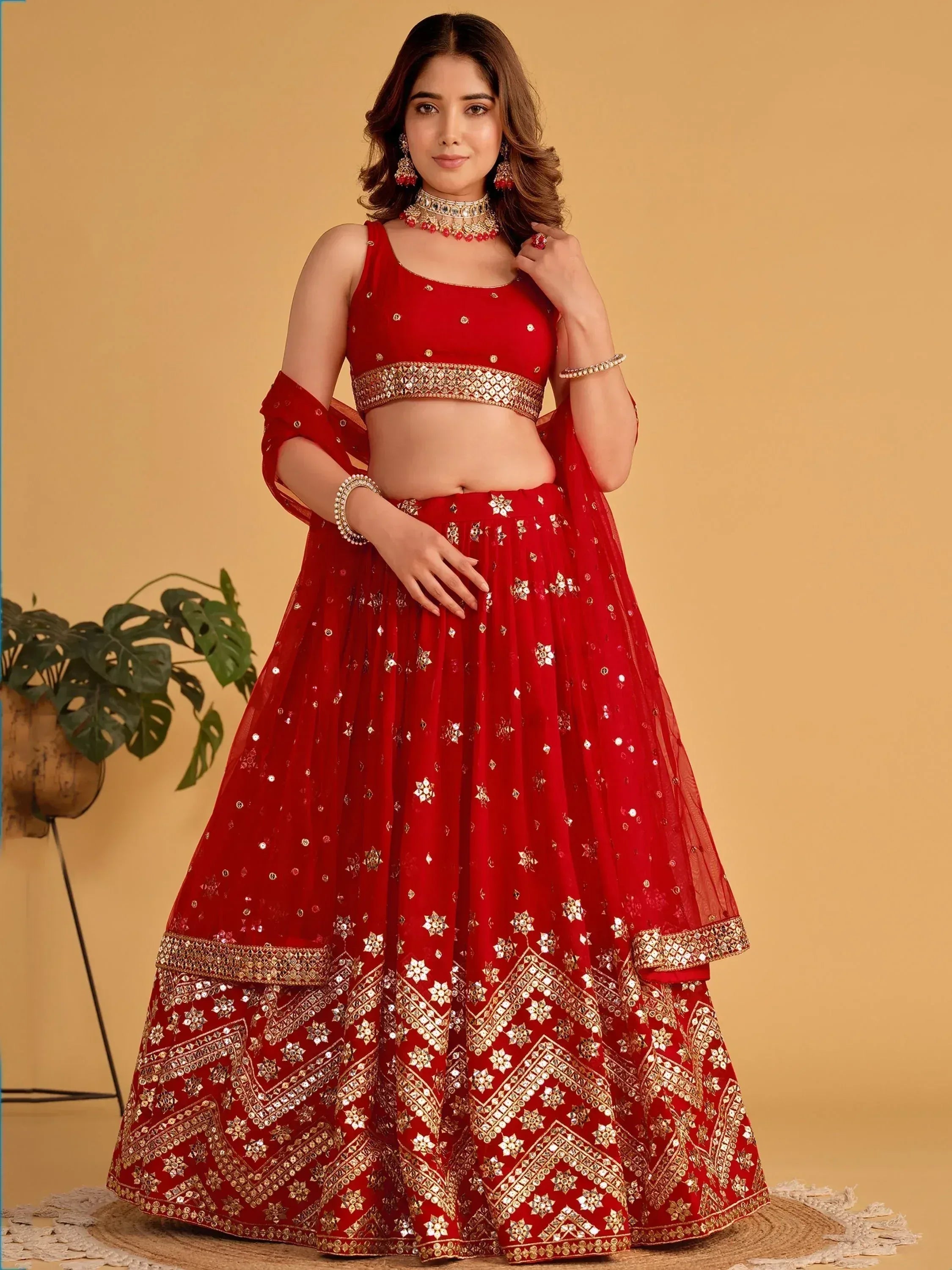 Red designer lehenga choli with gold mirror work, perfect for Indian weddings and festive occasions