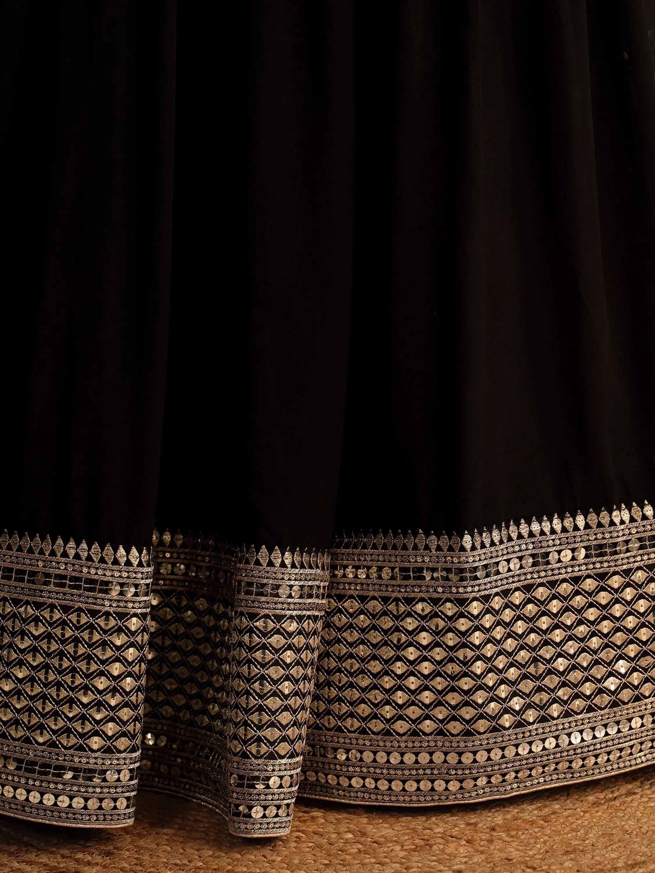 Black ethnic gown with gold mirror work and intricate embroidery, perfect for festive occasions.