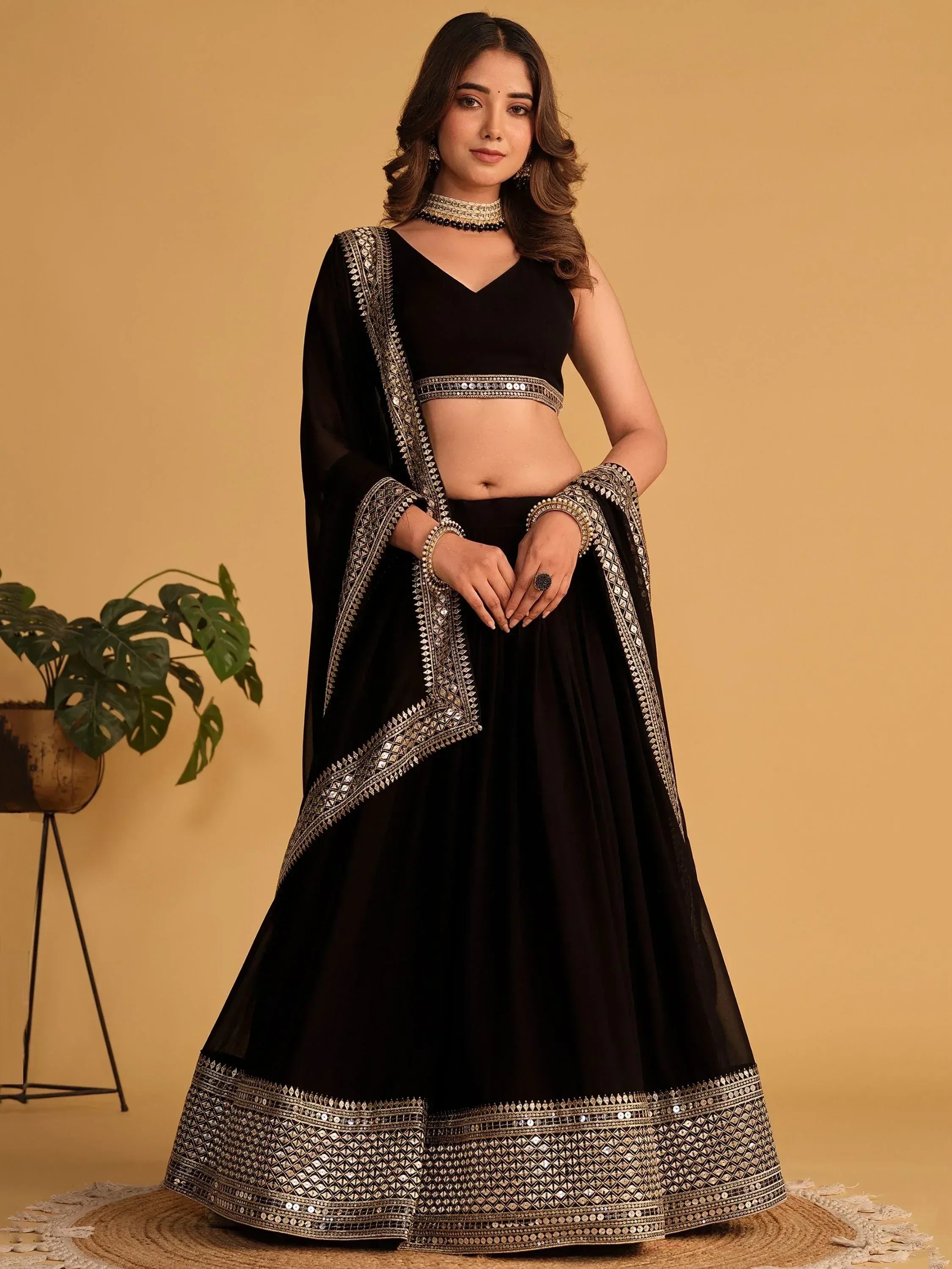 Black designer lehenga choli with gold mirror work, perfect for Indian ethnic wear occasions.