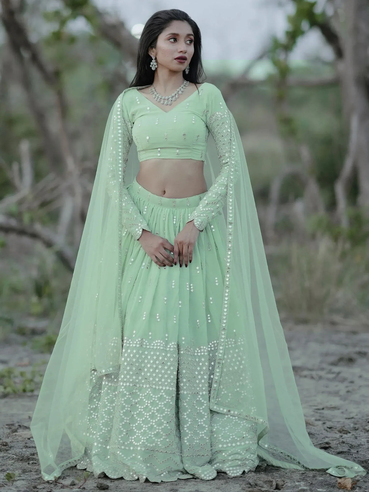 Mint green designer lehenga choli with mirror work and sheer cape, perfect for ethnic occasions.