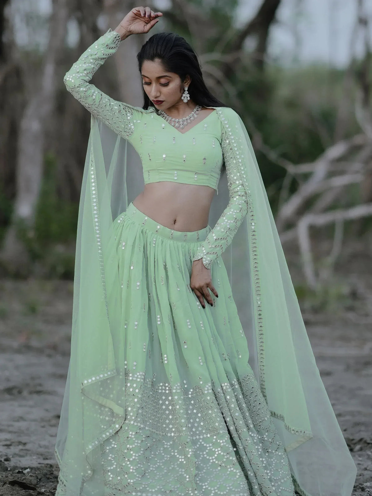 Mint green designer lehenga choli with mirror work and sheer dupatta, perfect for ethnic occasions.