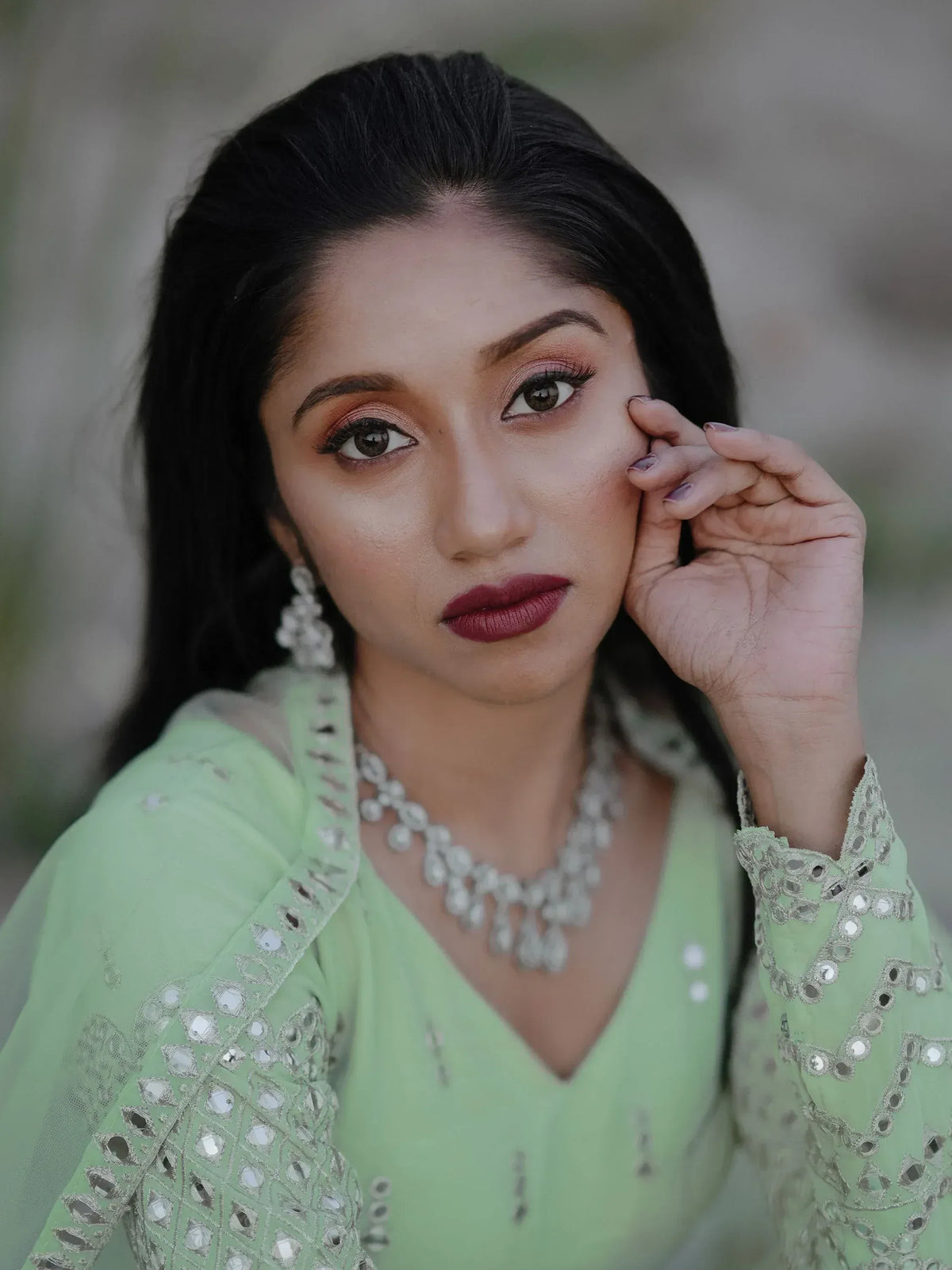 Elegant woman in mint green ethnic wear with mirror work and pearl jewelry