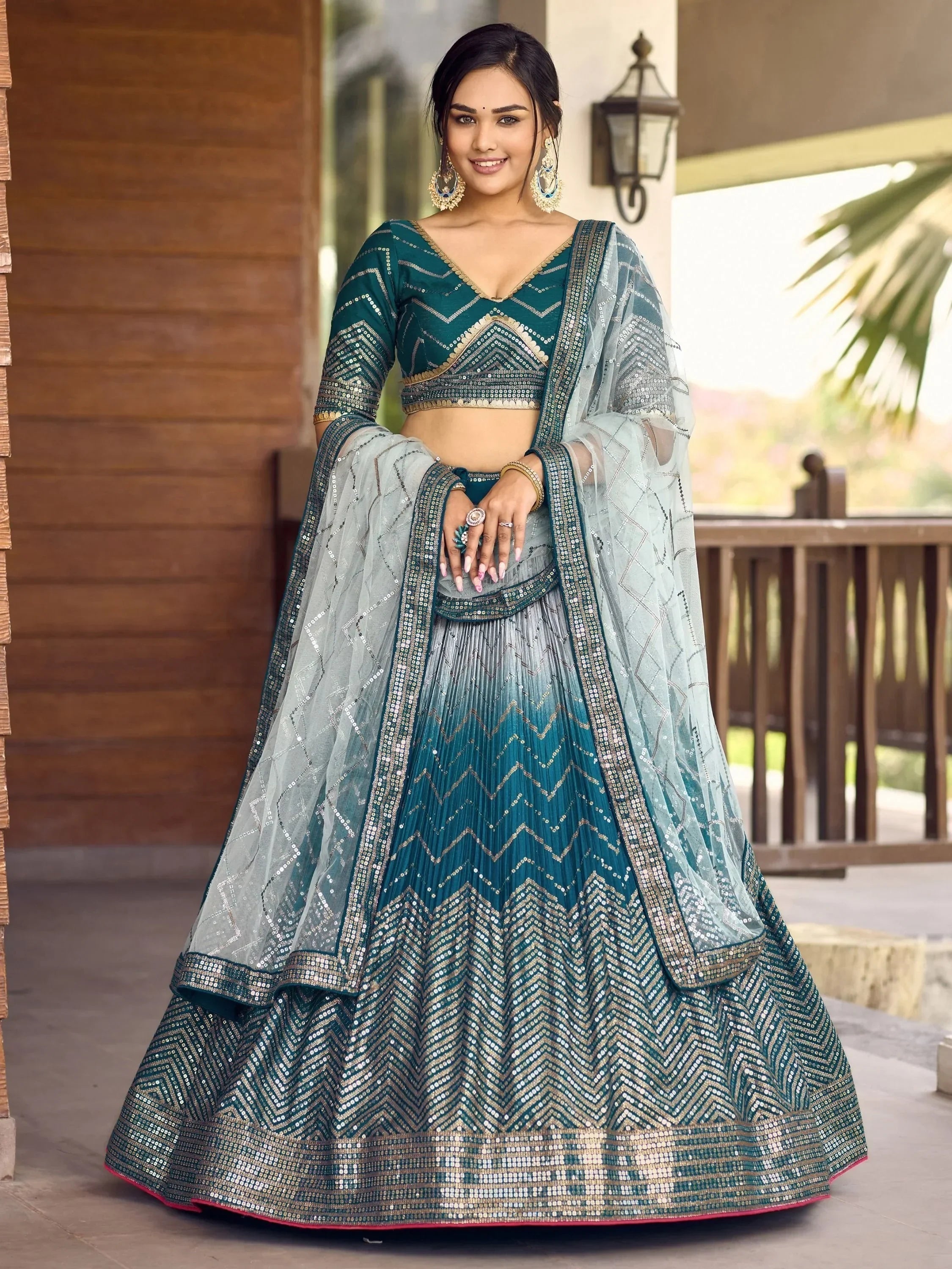 Teal and silver sequin lehenga choli with geometric embroidery, perfect for Indian weddings and festive occasions.