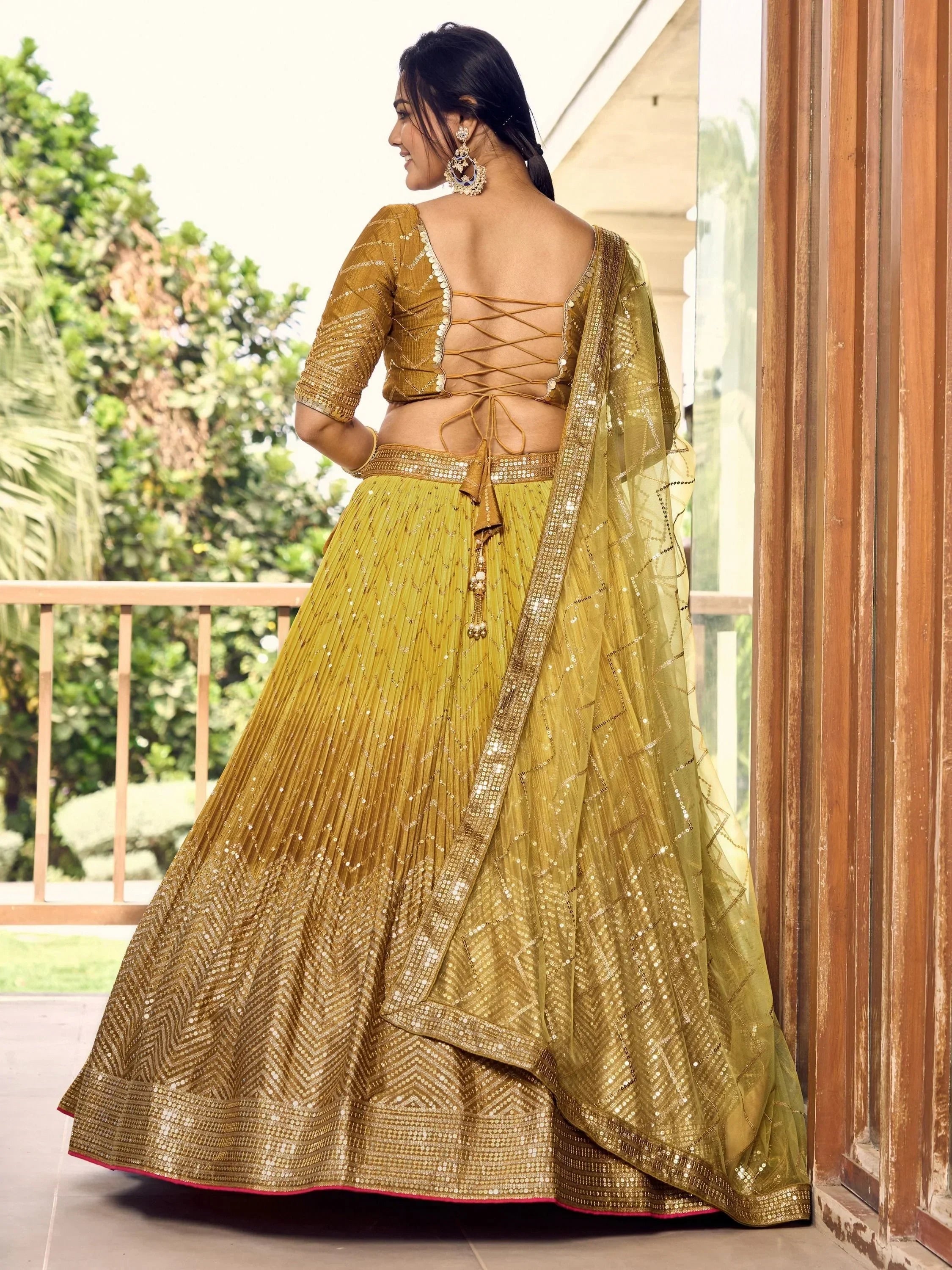 Golden designer lehenga choli with back lace-up blouse and sequin work, perfect for Indian ethnic wear events.