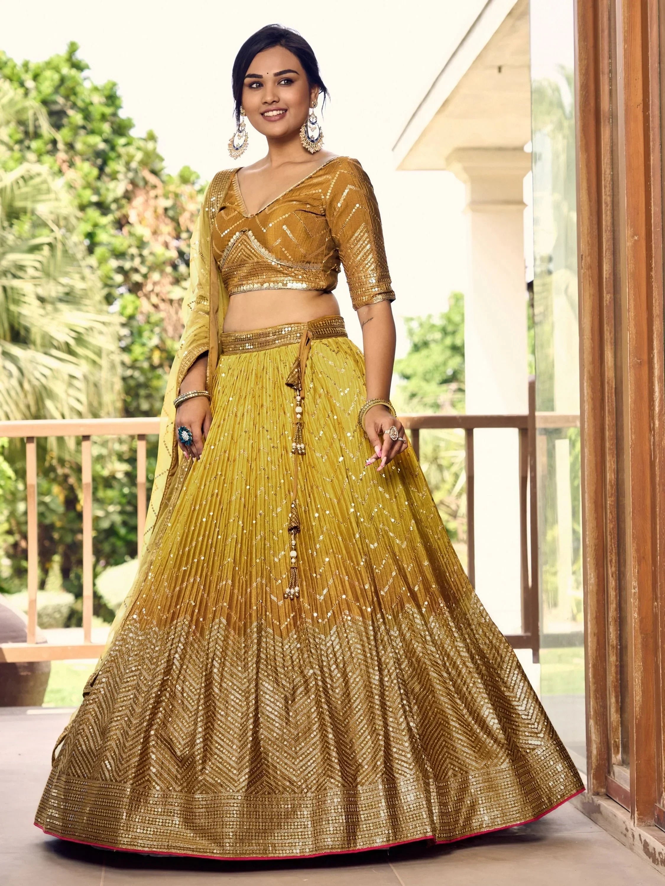Golden sequin lehenga choli with V-neck blouse and pleated skirt, perfect for Indian weddings and festive occasions.