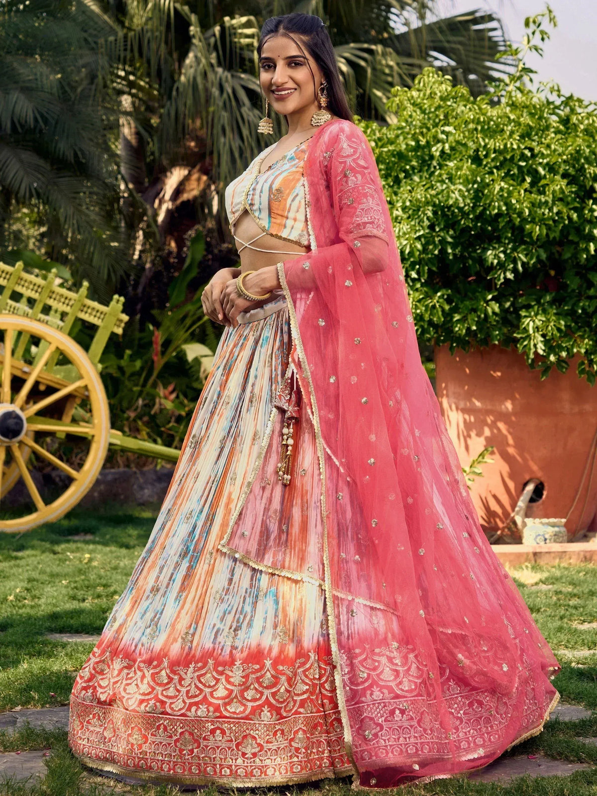 Woman in colorful designer lehenga choli with pink dupatta, perfect for Indian ethnic occasions