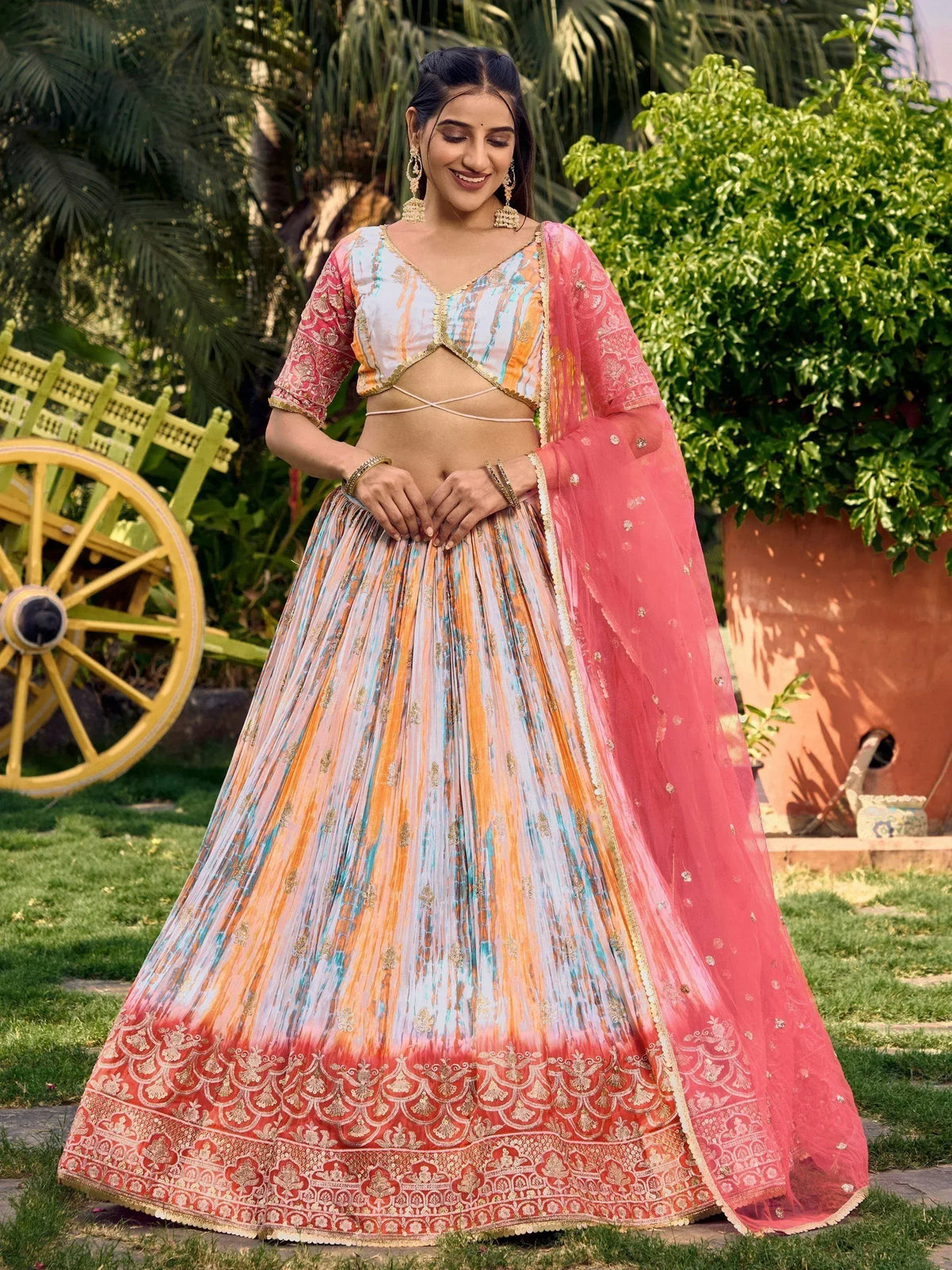 Woman in colorful designer lehenga choli with pink dupatta, perfect for Indian ethnic wear occasions