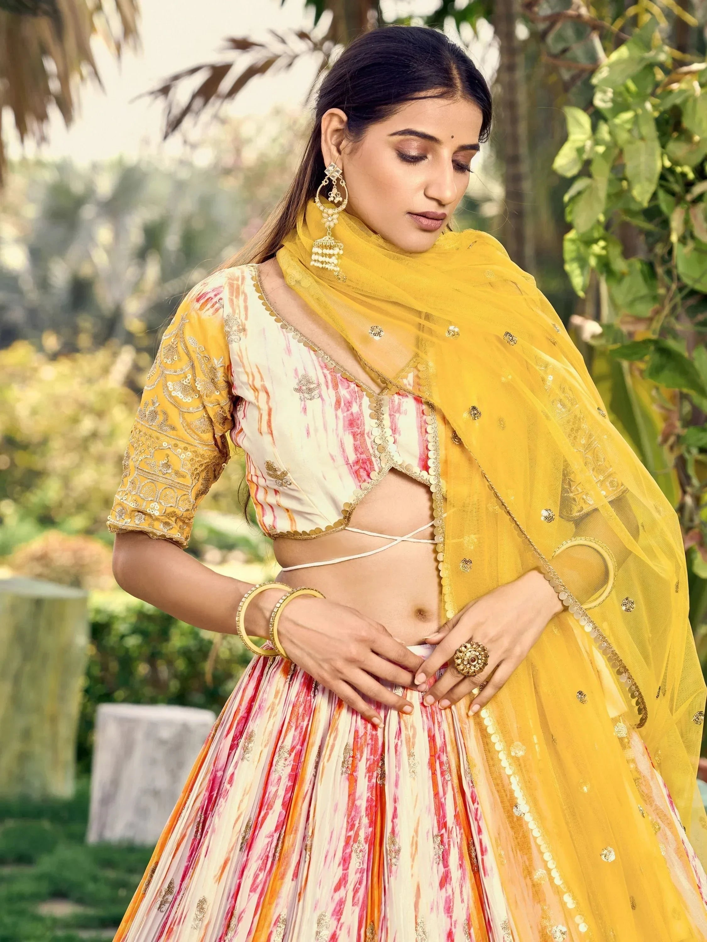 Woman in vibrant yellow and pink embroidered lehenga choli with dupatta, perfect for Indian ethnic occasions