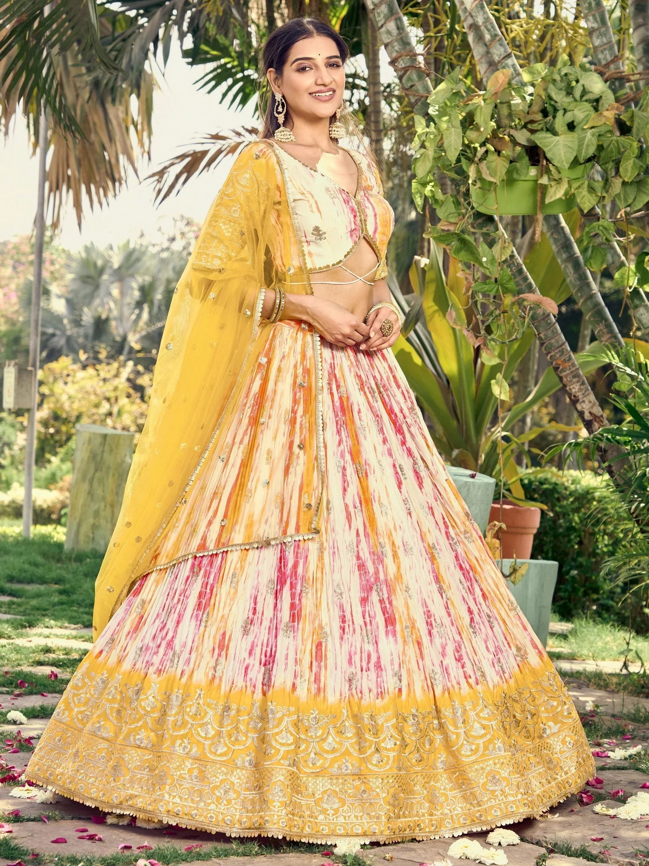 Yellow and pink tie-dye lehenga choli with gold embroidery, perfect for Indian ethnic wear occasions.