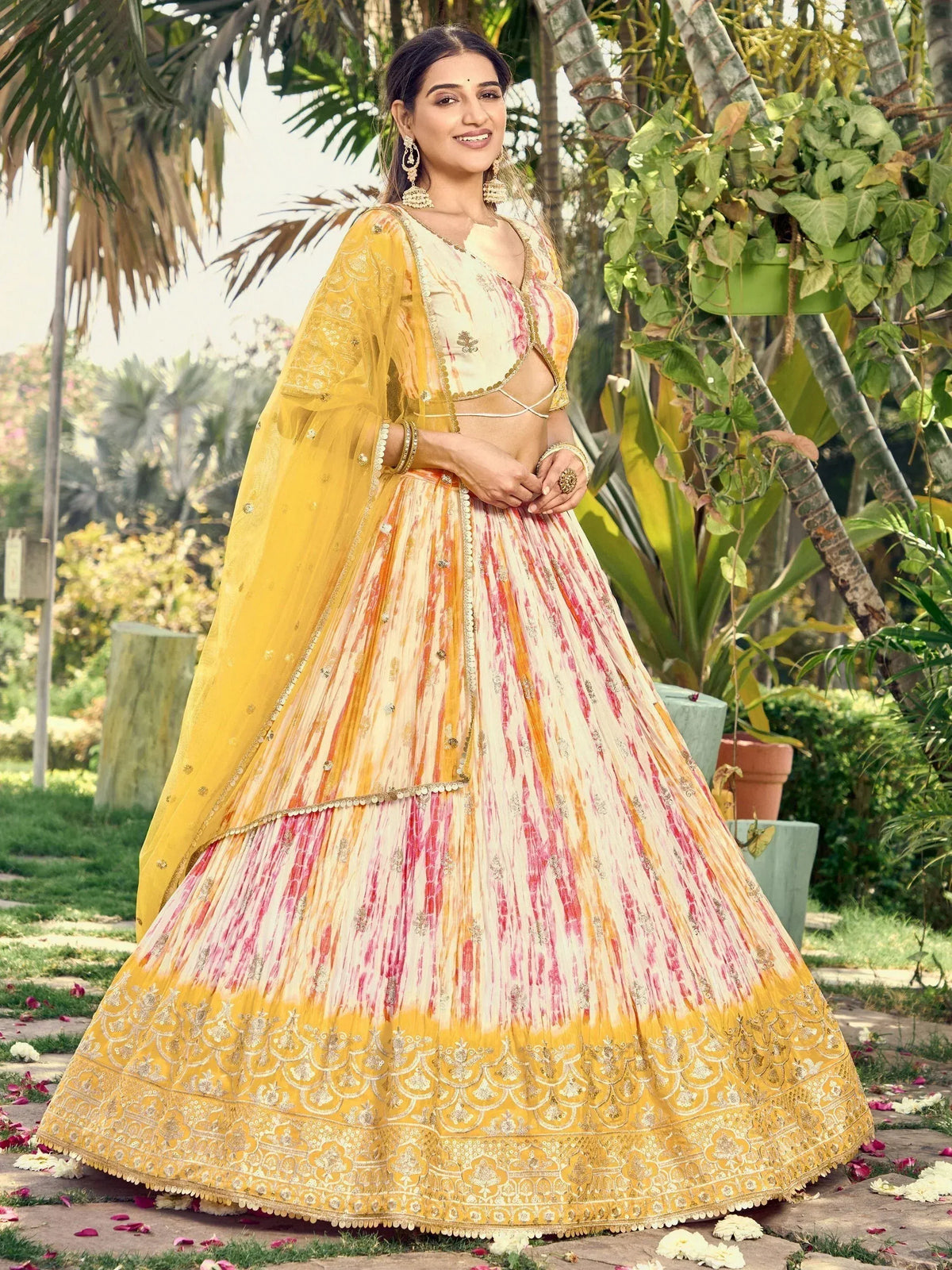 Yellow and pink tie-dye lehenga choli with gold embroidery, perfect for Indian ethnic wear occasions.