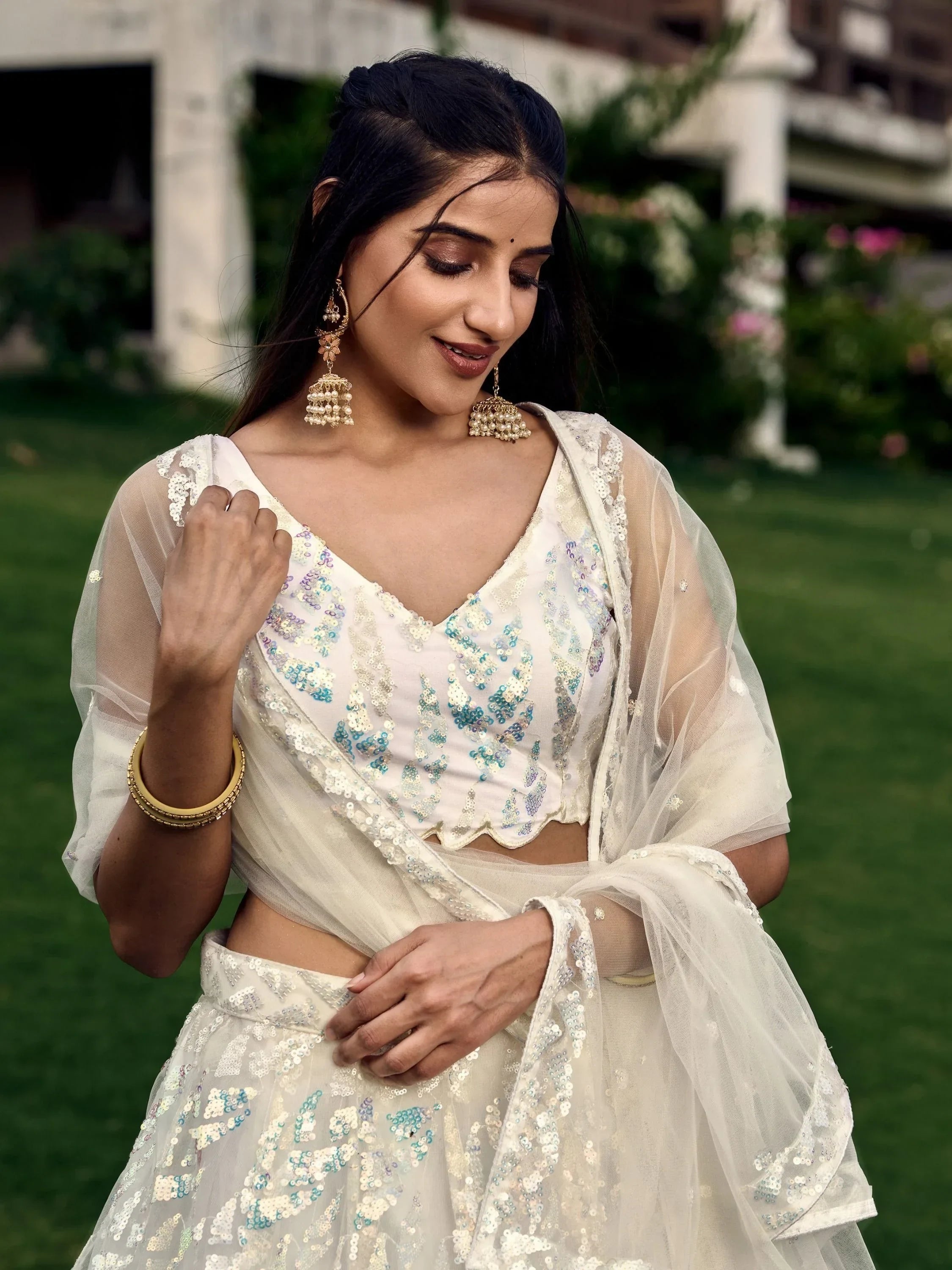 Elegant white sequin lehenga choli with sheer dupatta, perfect for Indian ethnic wear and festive occasions.