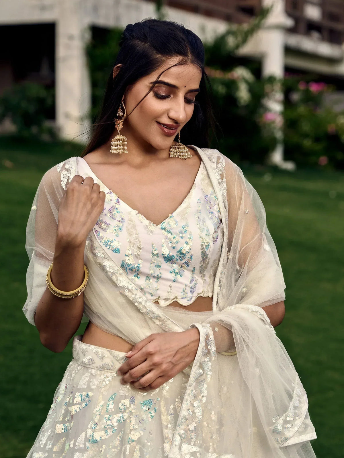 Elegant white sequin lehenga choli with sheer dupatta, perfect for Indian ethnic wear and festive occasions.
