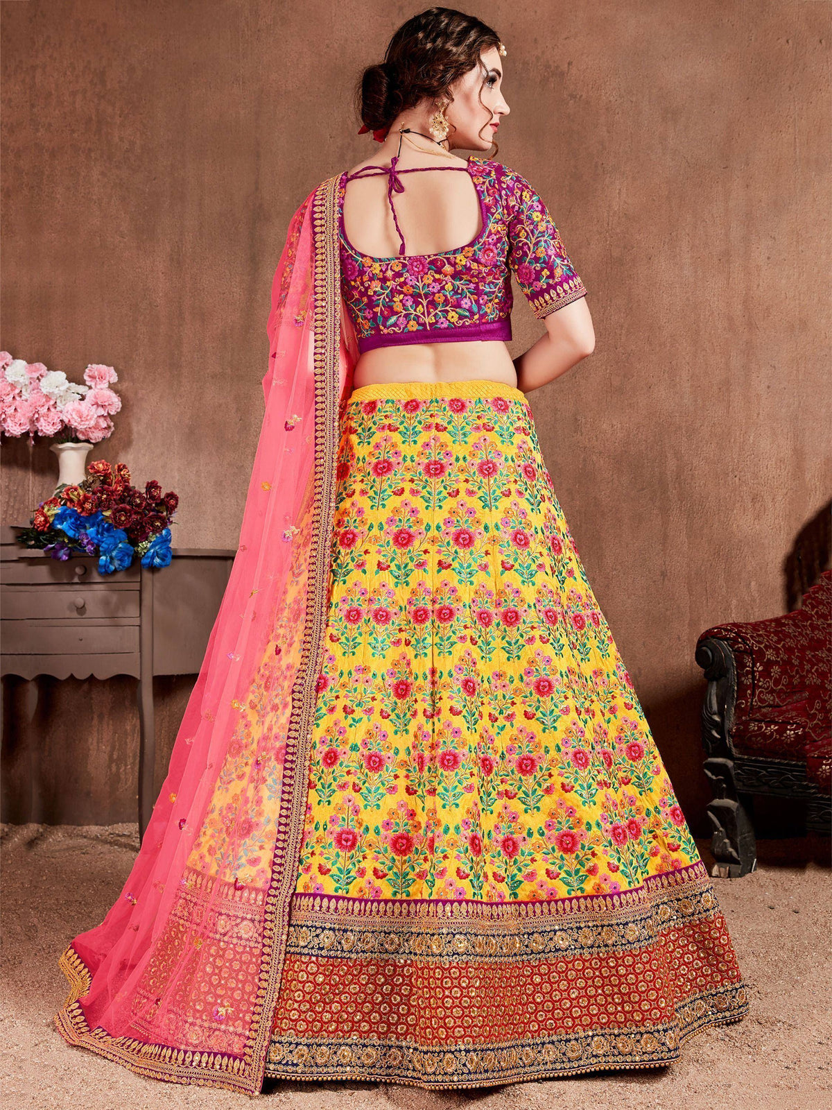 Vibrant yellow floral lehenga choli with pink dupatta, perfect for Indian ethnic occasions