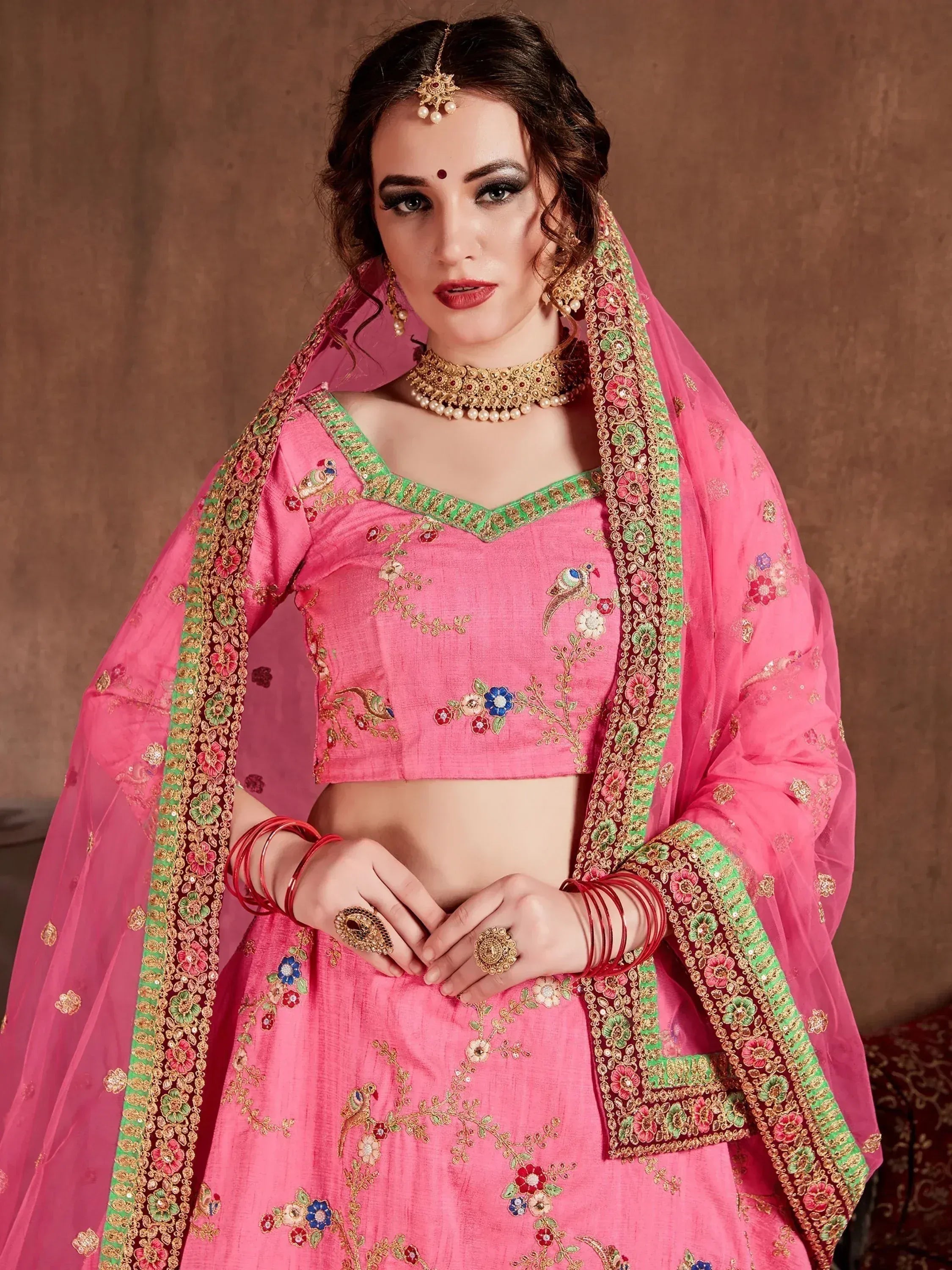 Pink embroidered lehenga choli with floral and peacock motifs, green border, and matching dupatta for Indian ethnic wear