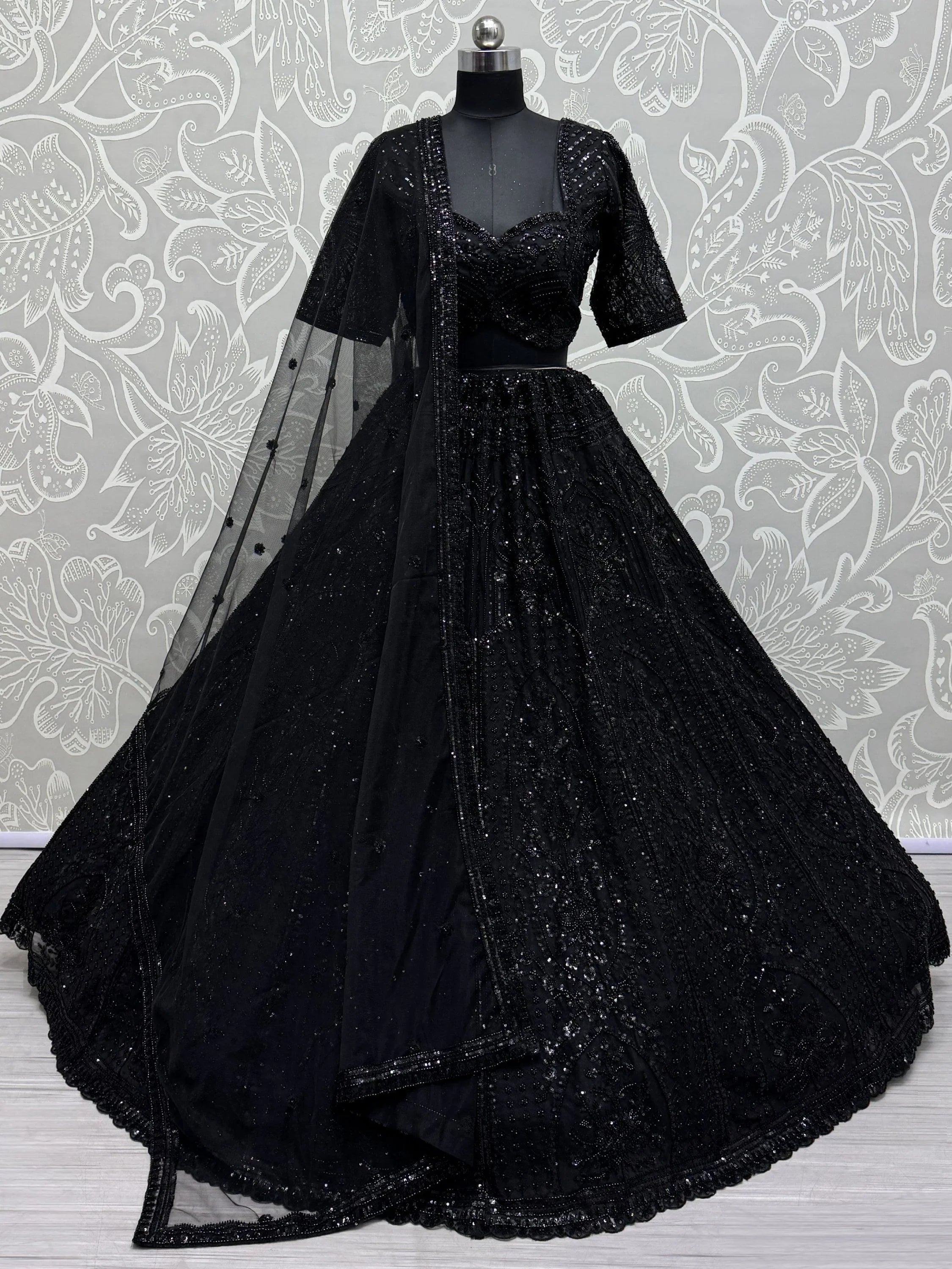 Black bridal lehenga choli with sequin embroidery and net dupatta on mannequin