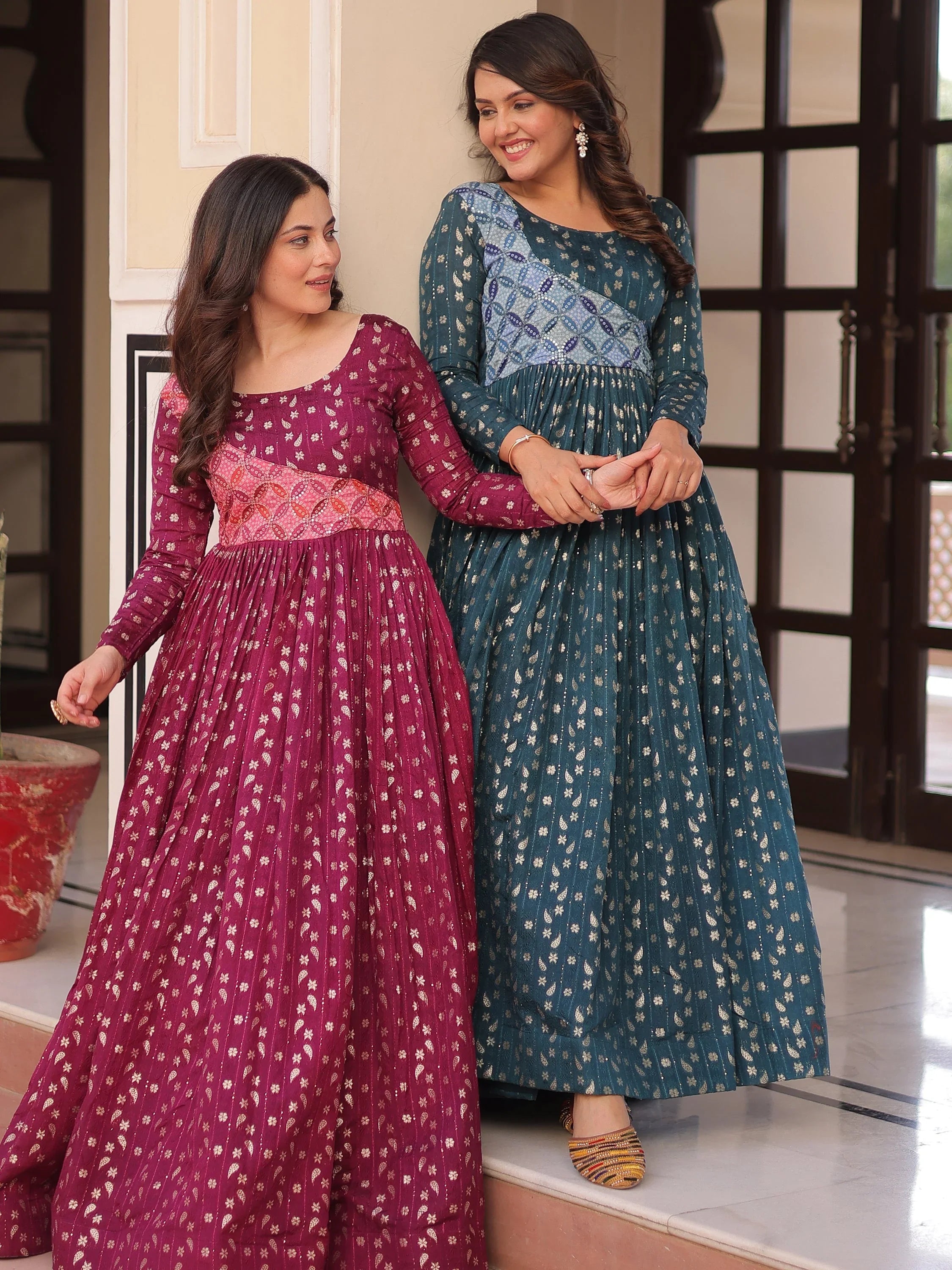 Women in traditional Indian ethnic gowns with gold motifs, maroon and teal colors