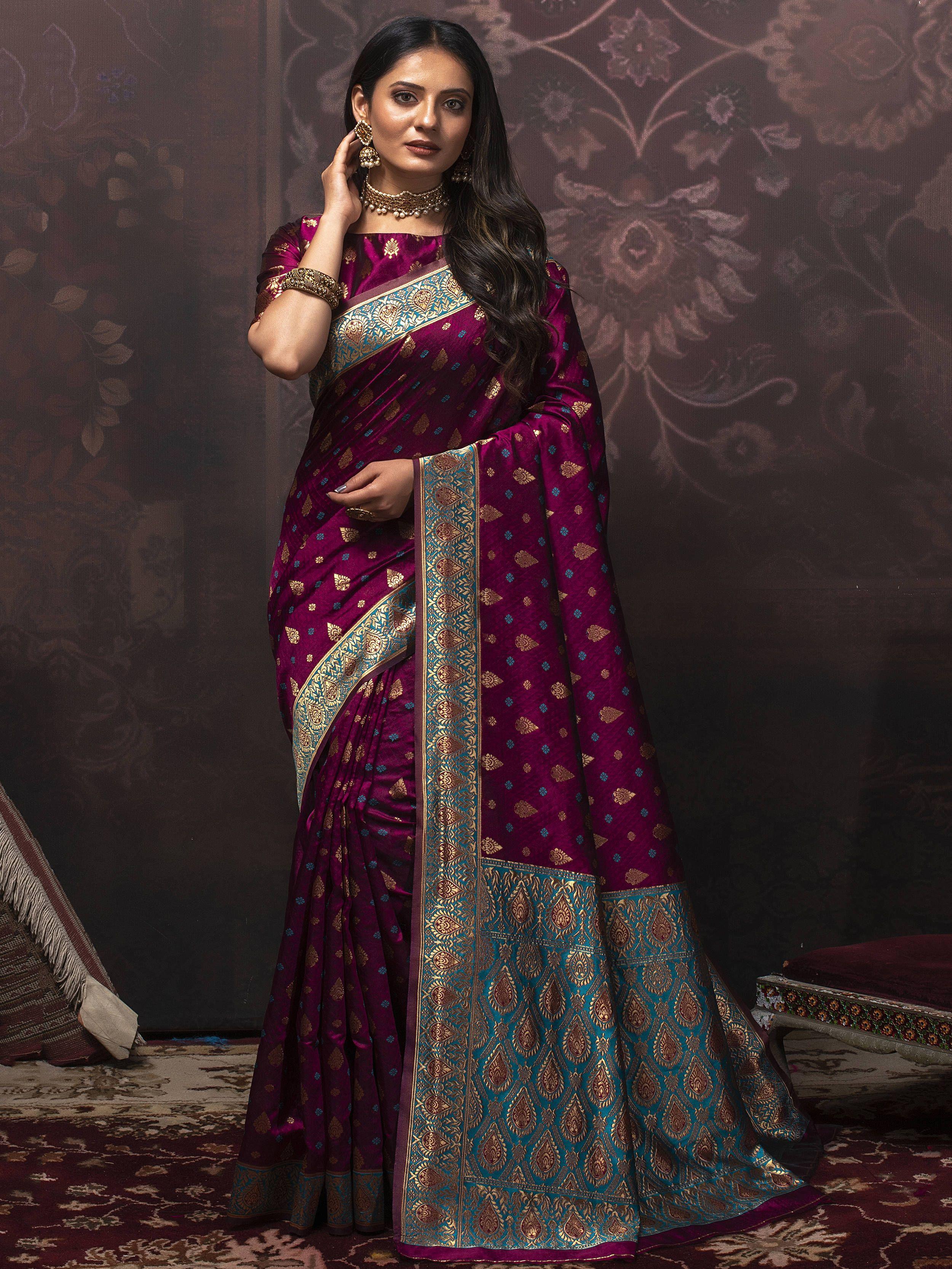 Woman in a purple Banarasi saree with gold motifs and blue embroidered border