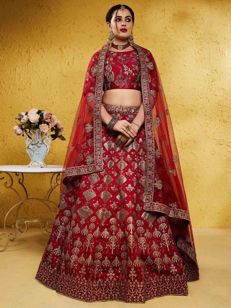 Woman wearing red mulberry silk bridal lehenga choli with gold embroidery and net dupatta