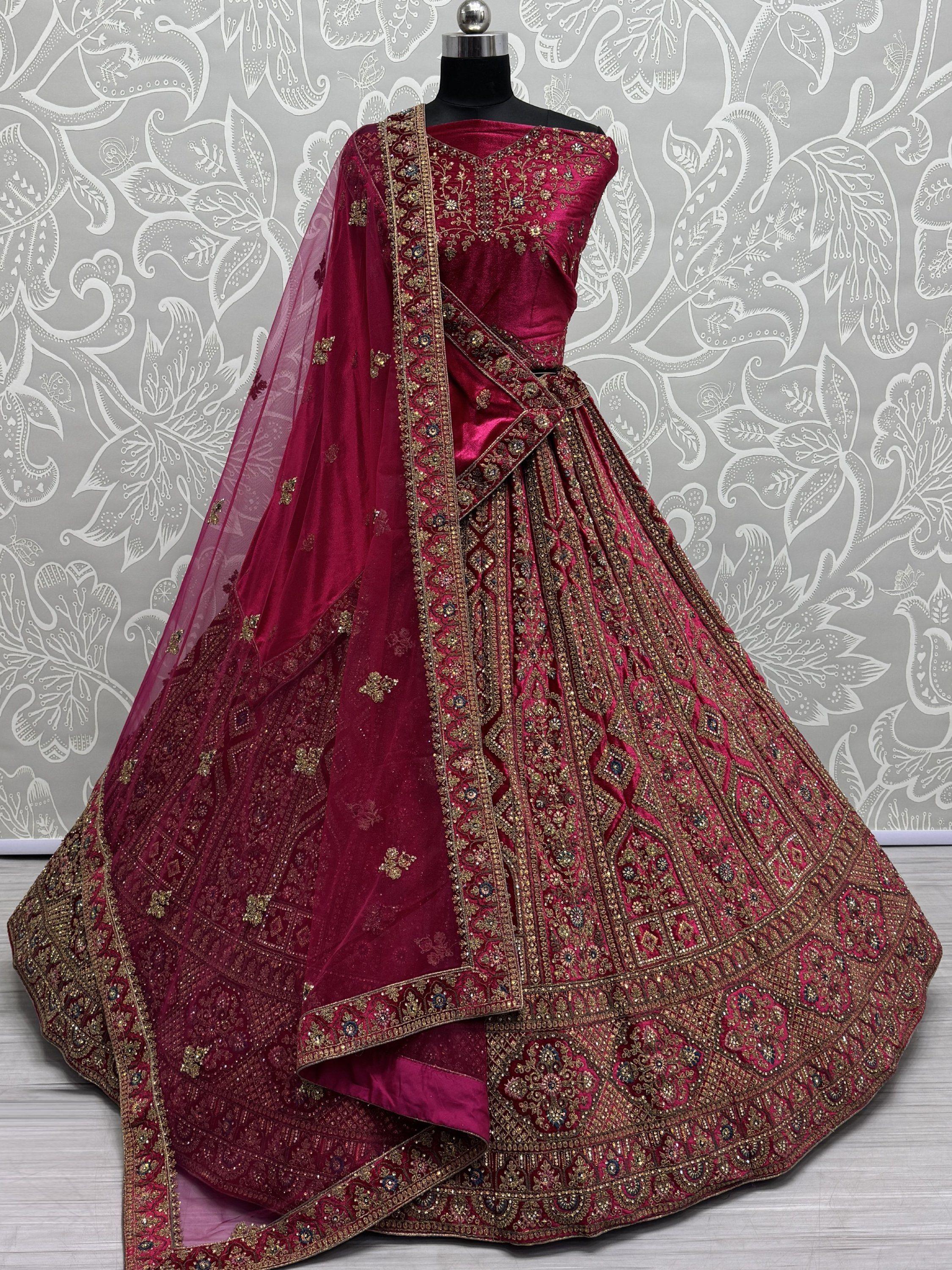 Bridal maroon lehenga choli with heavy gold embroidery and matching dupatta on mannequin