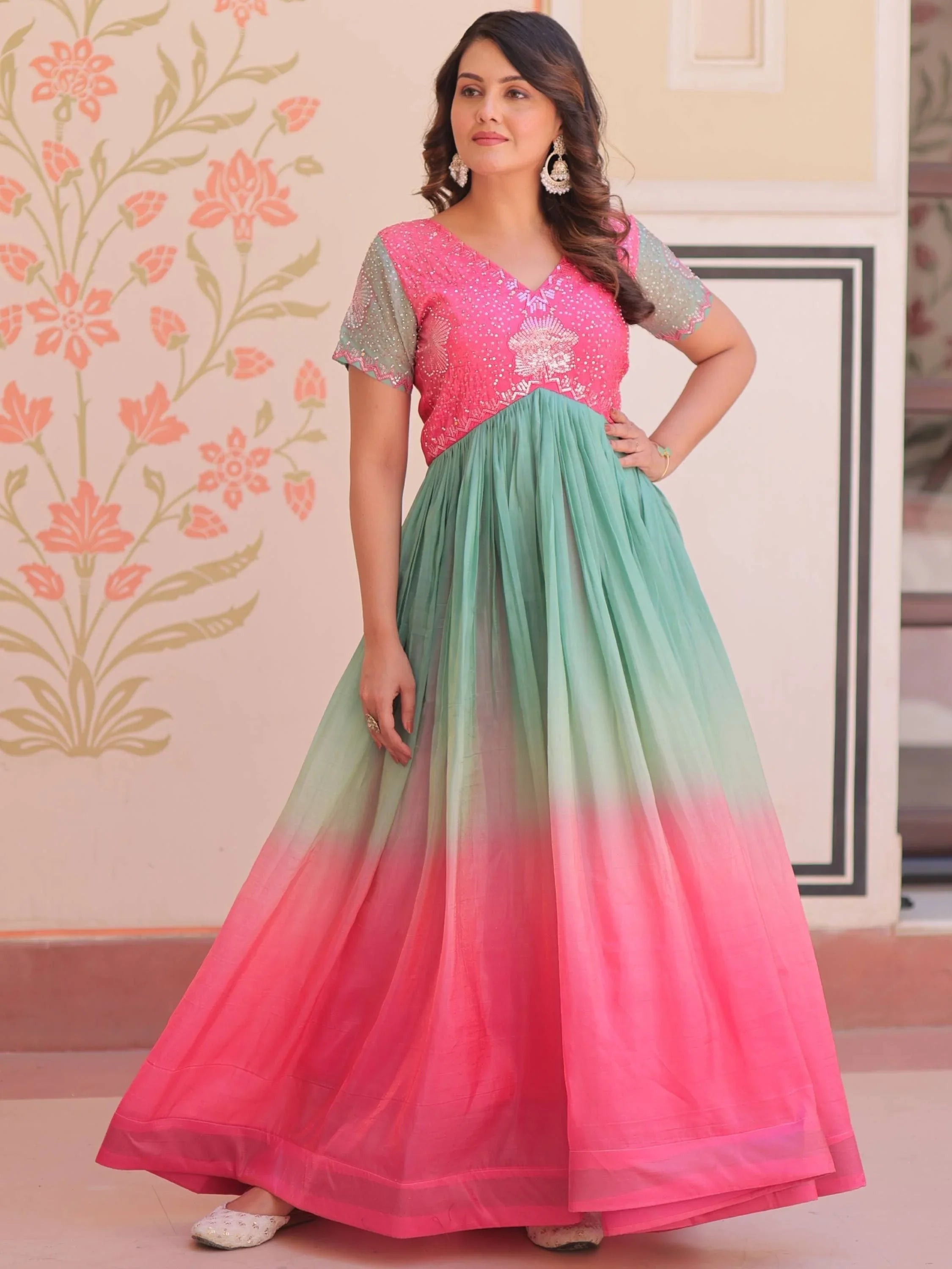 Woman wearing multicolor engagement gown with pink embroidered bodice and ombre skirt.