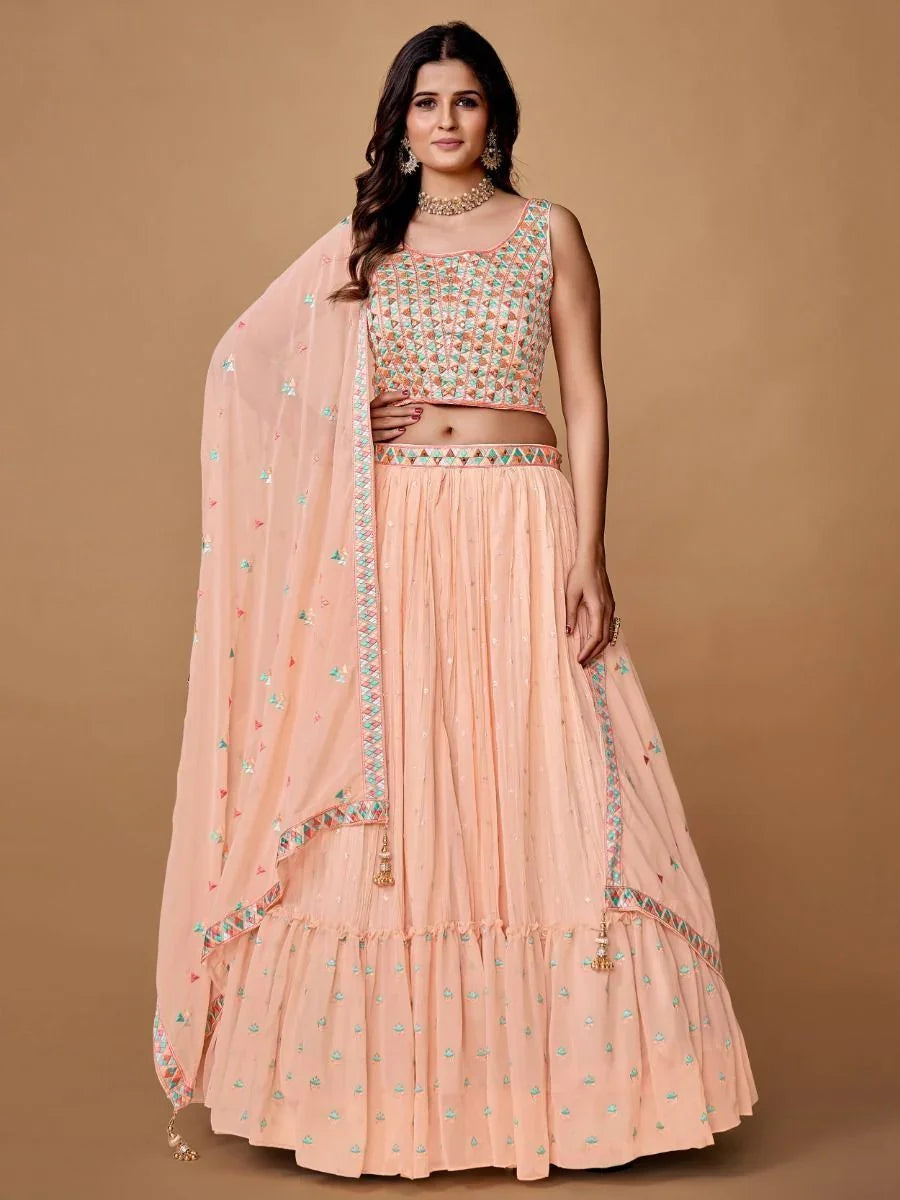 Peach Bollywood lehenga choli with embroidery, matching sheer dupatta, and traditional jewelry