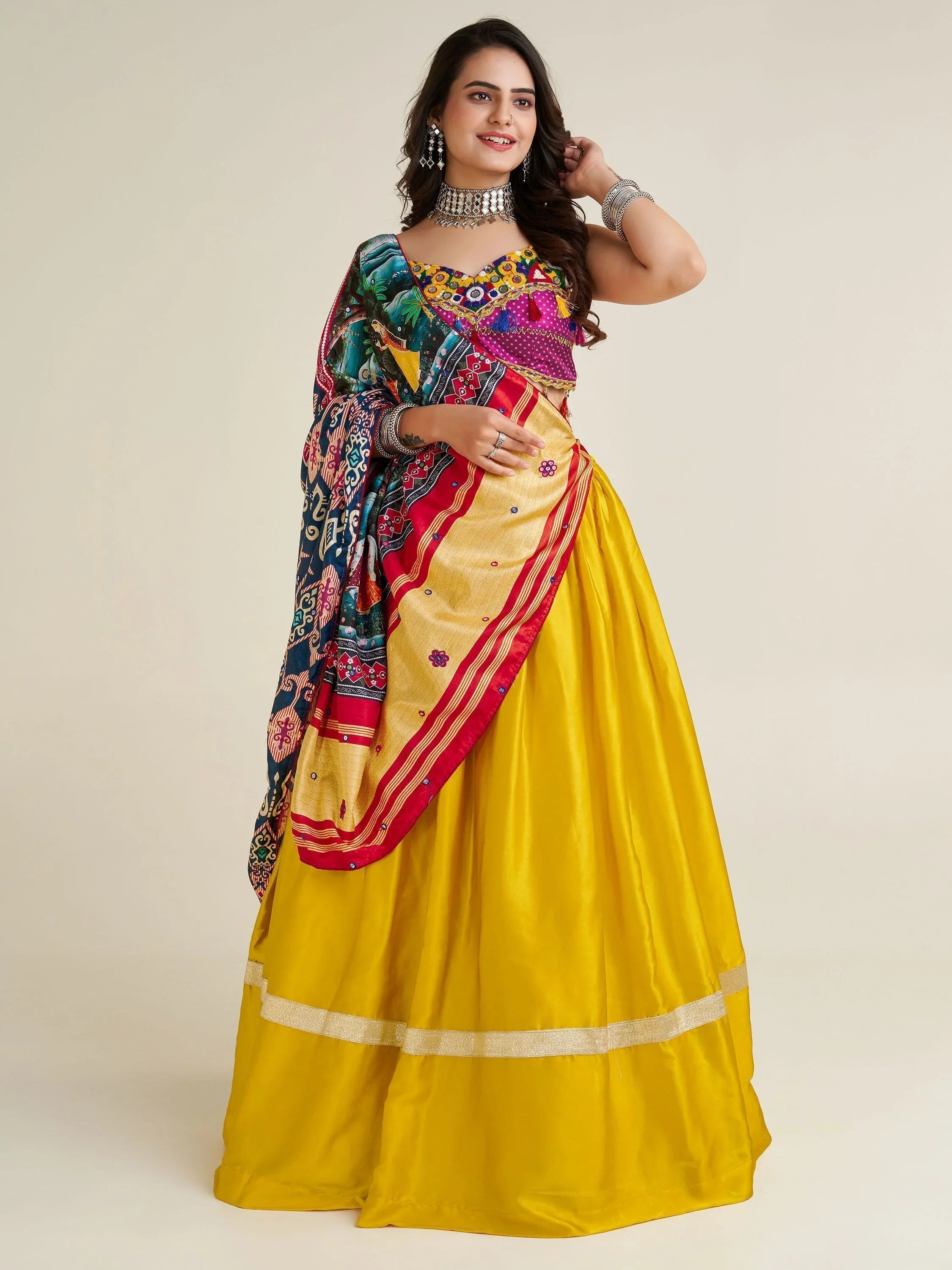 Woman wearing vibrant yellow satin Navratri lehenga choli with multicolor dupatta and jewelry