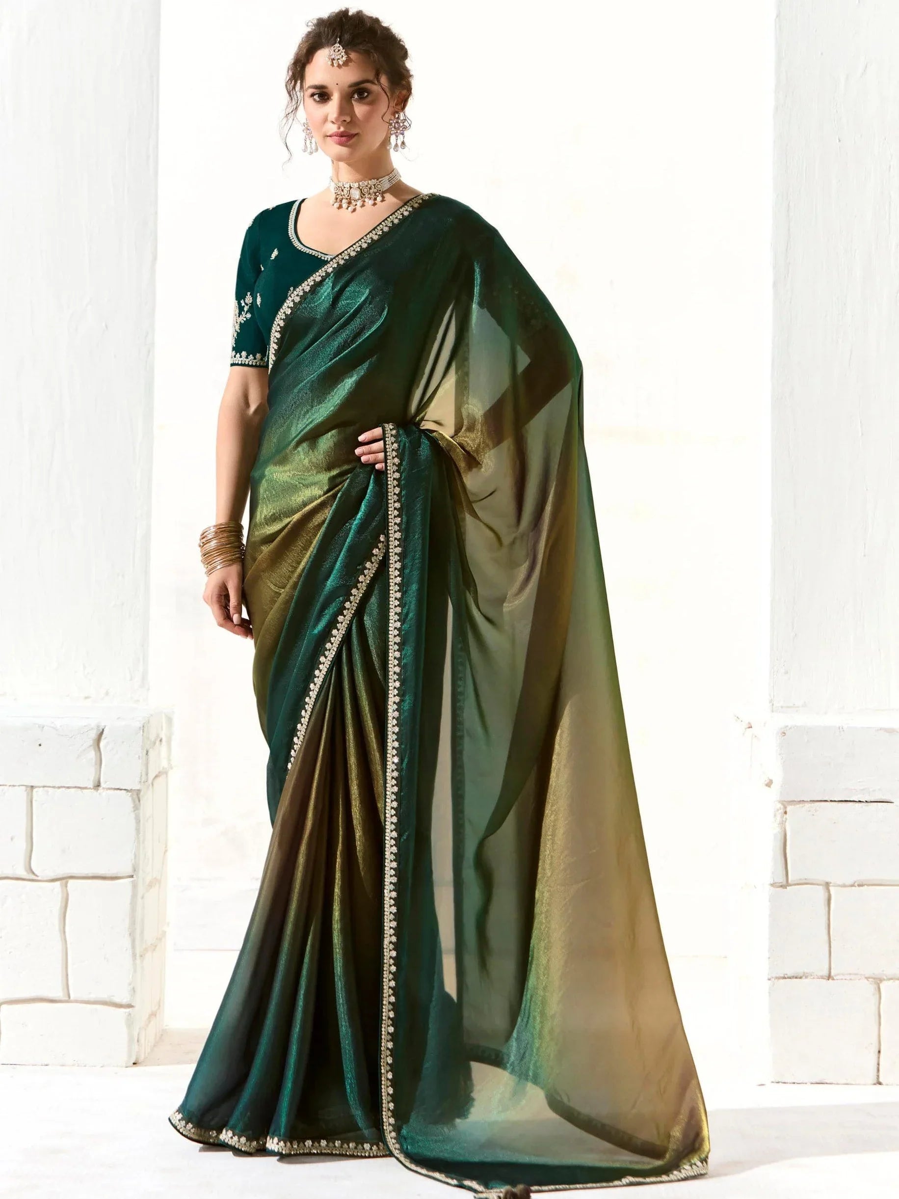 Woman wearing elegant green tissue Bollywood saree with embellished border and blouse