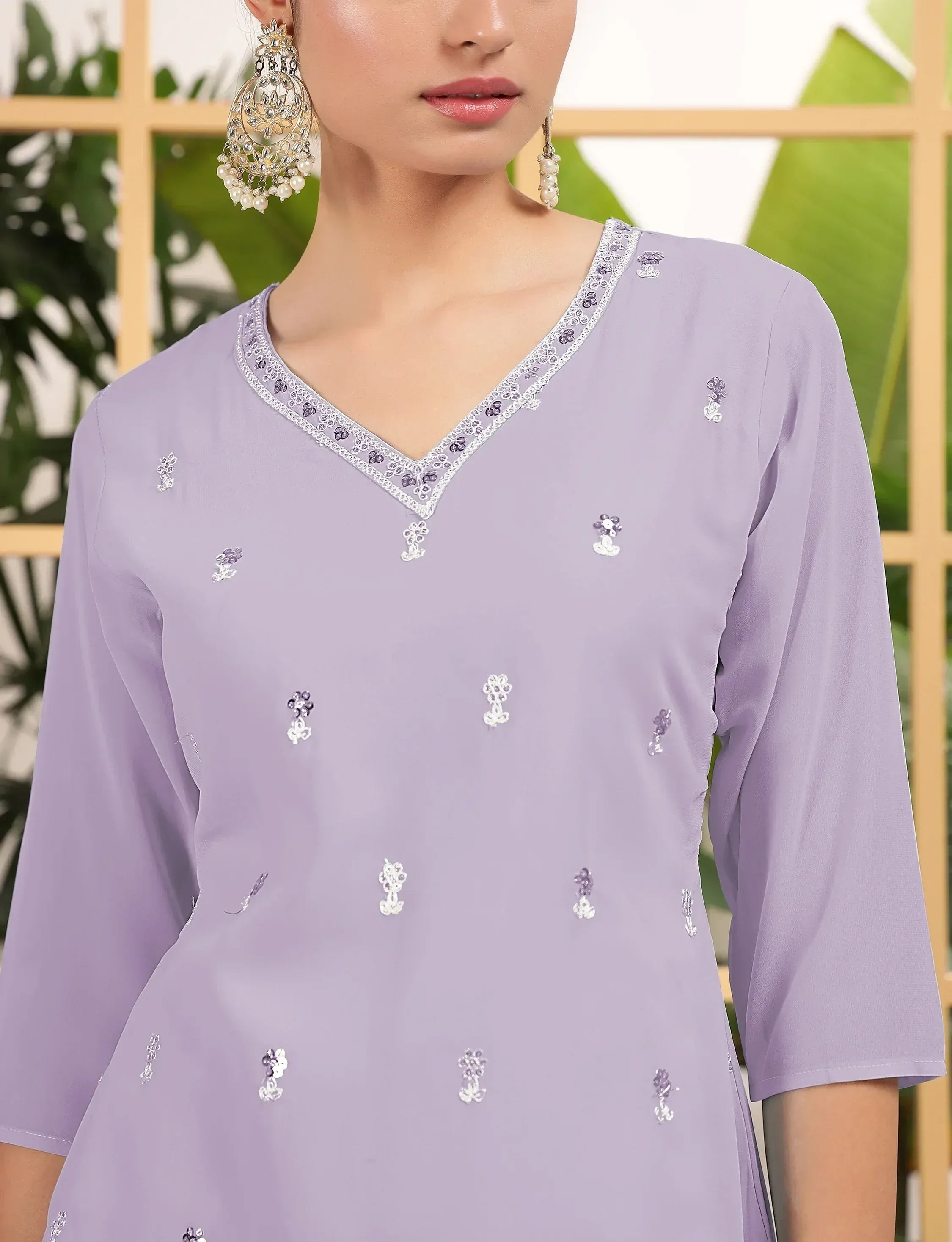 Lavender ethnic kurti with floral embroidery and V-neck, paired with statement earrings for Indian wear.