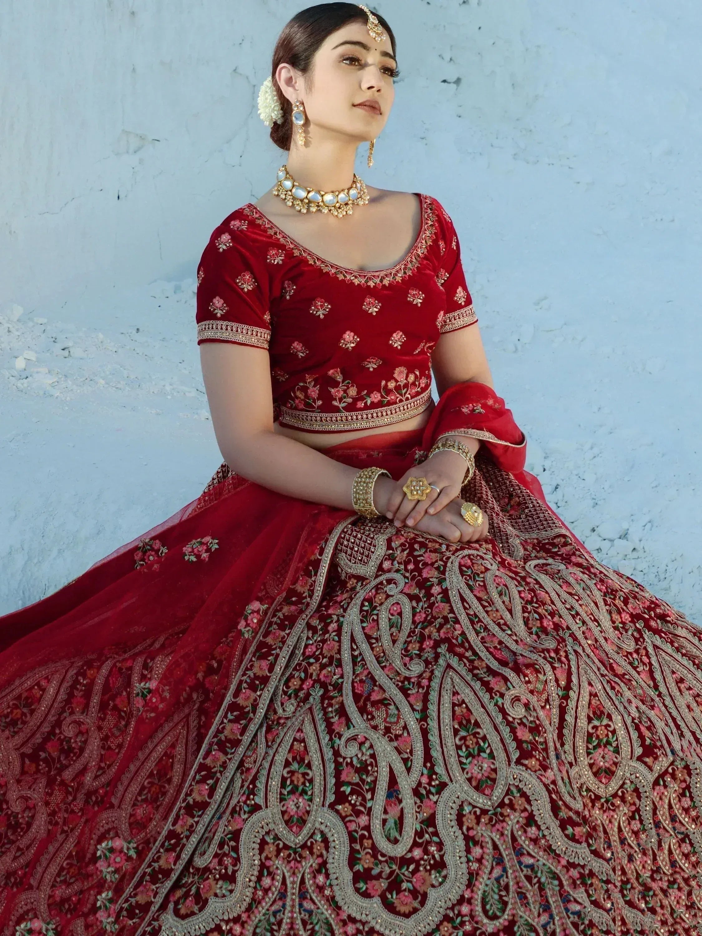 Red embroidered lehenga choli with gold detailing, perfect for Indian weddings and festive occasions.
