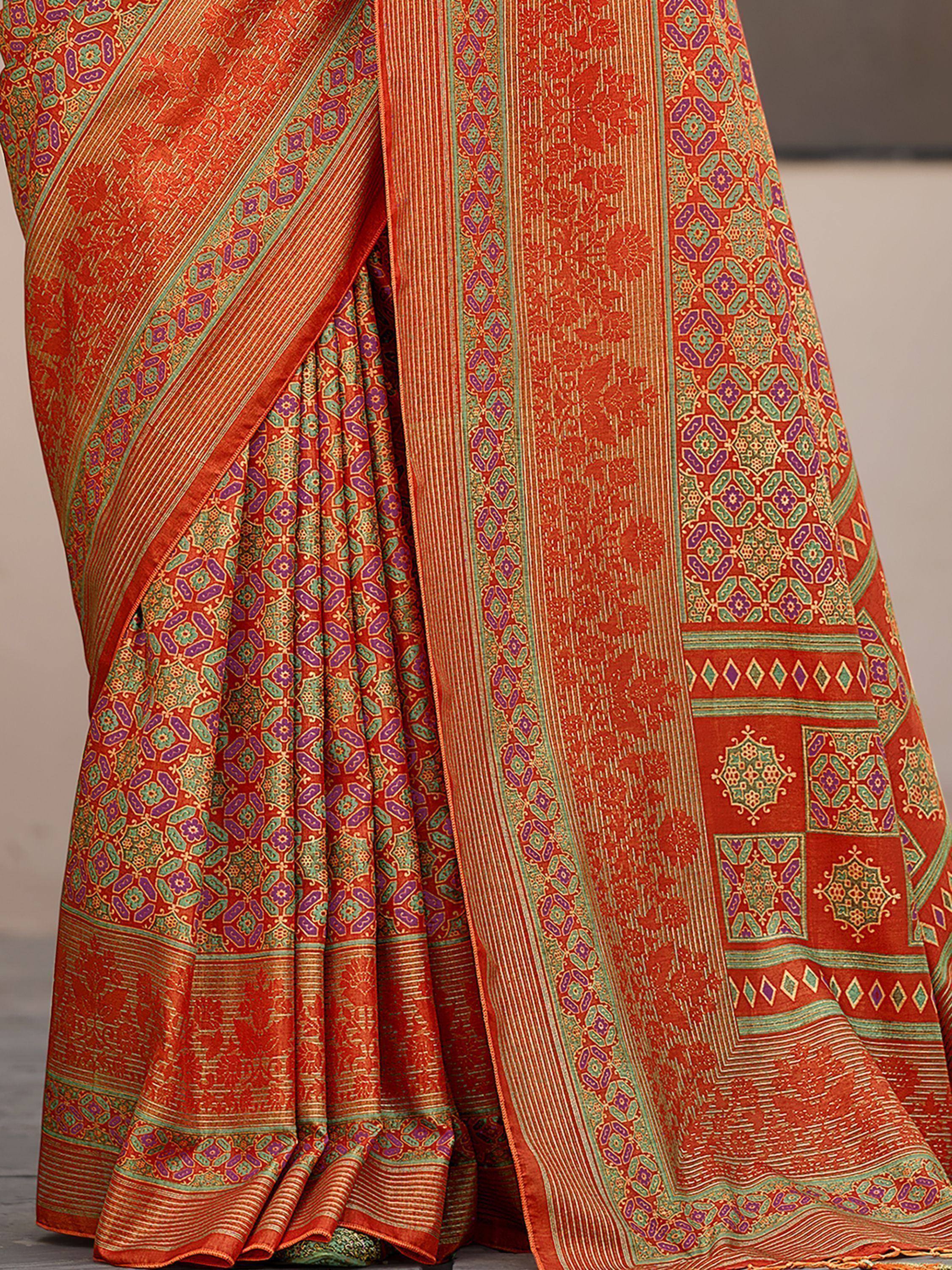 Vibrant orange saree with intricate green and purple geometric patterns, perfect for ethnic wear.