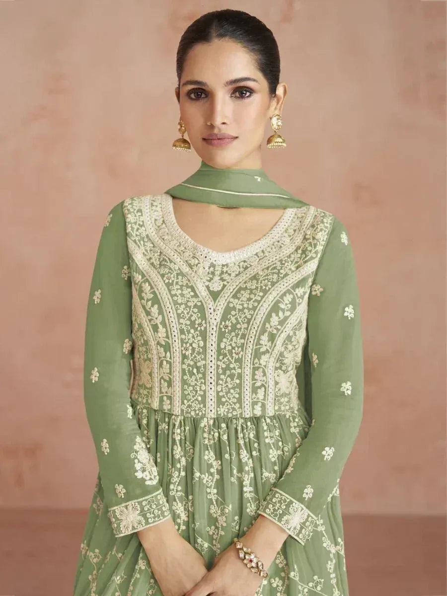 Woman wearing green embroidered ethnic gown with dupatta and gold jhumka earrings